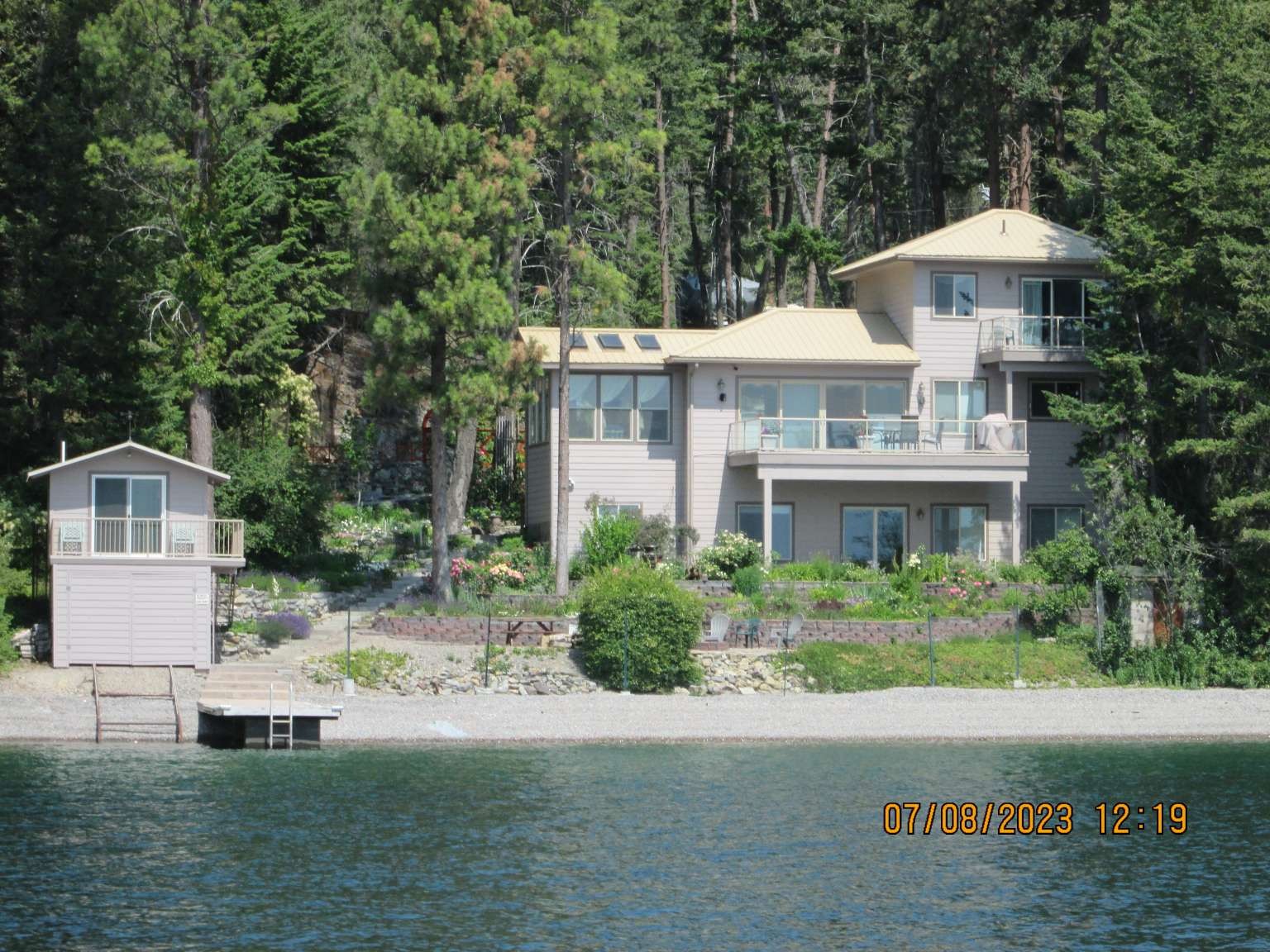 This is one of the best view properties Flathead Lake has to offer. A real gem! A southern view with a gentle sloping  gravel beach, a newer cement dock, enclosed boathouse with a rail boat launching system and guest quarters with a full bath, complement this beautiful property. The main house has three bedrooms, 2.5 baths and a two-car attached garage. A cozy guest/hobby shop cabin is attached to the garage. The property also has a 34 x 40 finished shop and full bathroom. The main house has a large daylight basement, a main floor living area and a third story primary bedroom suite. The entire property is enclosed in a 6 foot chain-link fence to protect the fabulous landscaping. The property has water rights for both the well and lake usage.