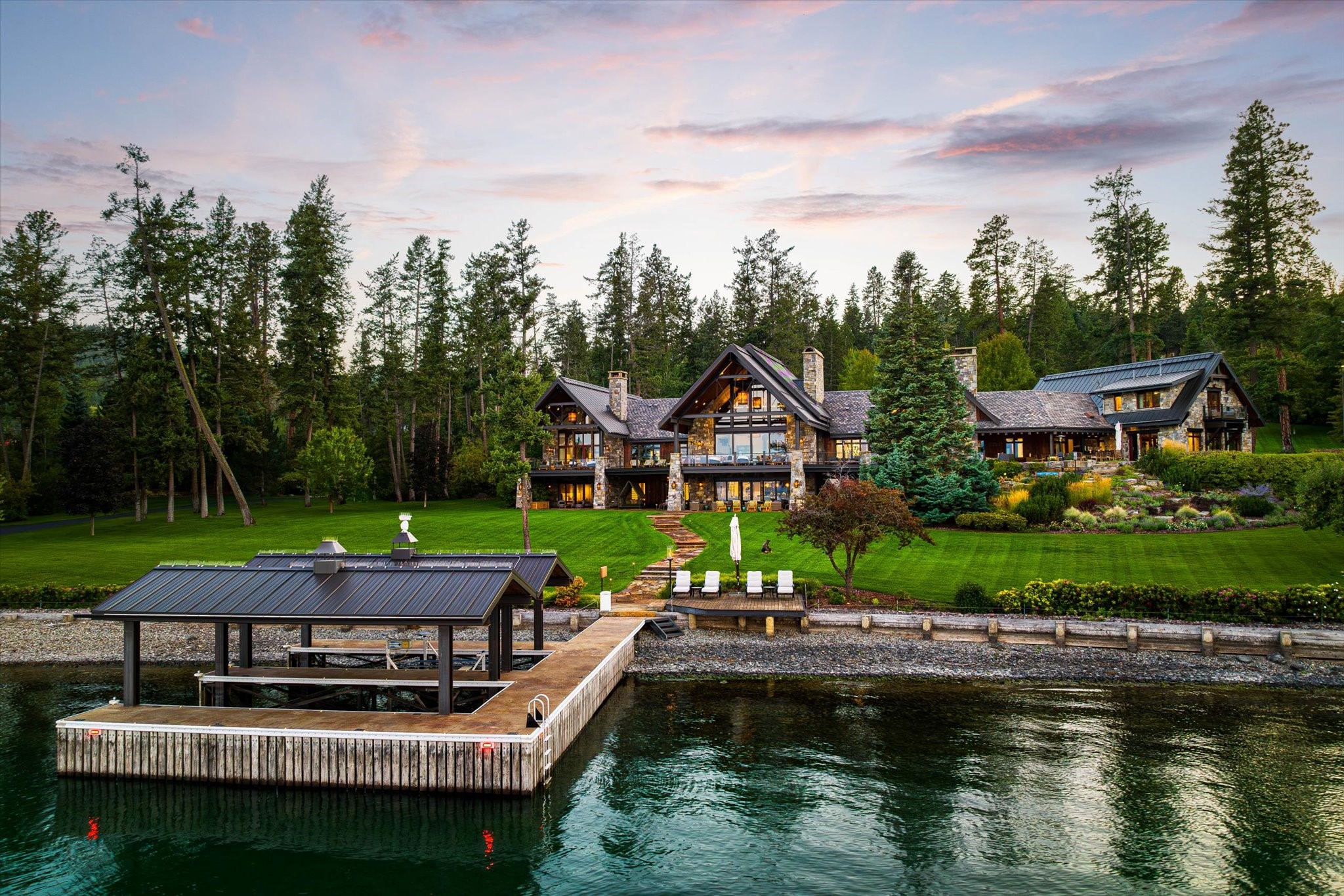 This Flathead Lake masterpiece was designed and constructed by Orlan Sorensen of Landmark Builders in 2009, with new interior design and refinishing in 2023. The 15,264 sf home includes 520 ft of lake frontage on 5.85 acres. The great room includes an 'avalanche' rock fireplace with oversized boulders tumbling from ceiling to floor, and a bank of sliding glass panels that retract completely into stone walls. The downstairs entertaining space features a full bar, pool table, and updated theater.  There are 6 total bedrooms, including a 2-bedroom guest apartment above the garage with a separate kitchenette and living space. The home also features a total of five fireplaces, each with its own unique stone and steel design.