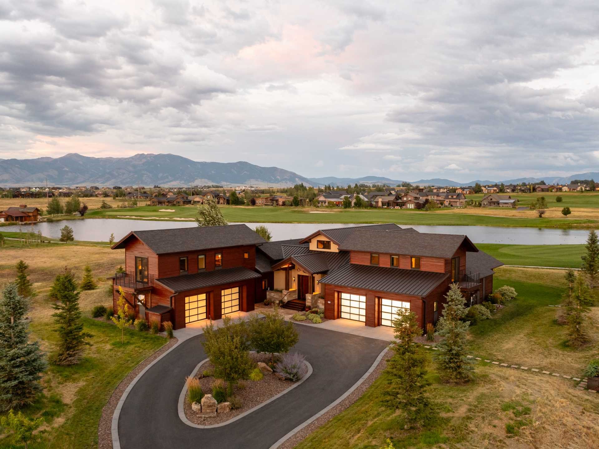 A truly one-of-a-kind custom home in Bozeman's exclusive Black Bull Golf Community, 550 Tillyfour Road stretches across two lots totaling nearly 1.5 acres. The home offers an incredible indoor-outdoor living experience, with massive sliding doors opening to a covered patio that gives way to the private community pond and the Bridgers in the distance. The level of detail continues into the kitchen, vaulted living area and exterior, with custom raised beds and a rich mahogany siding that offers a depth & character rarely seen. The home, designed by Bayliss Ward and built in 2016, finds most of its 4,529 SF primarily on the main level, with a truly massive master bedroom and bathroom situated in the rear of the home, a 1800+ bottle climate controlled wine room inside the separate pantry and a sleek, grand kitchen that's perfect for entertaining. Above each of the two 2 car garages are en-suite bedrooms, each with private balconies and views in different directions.