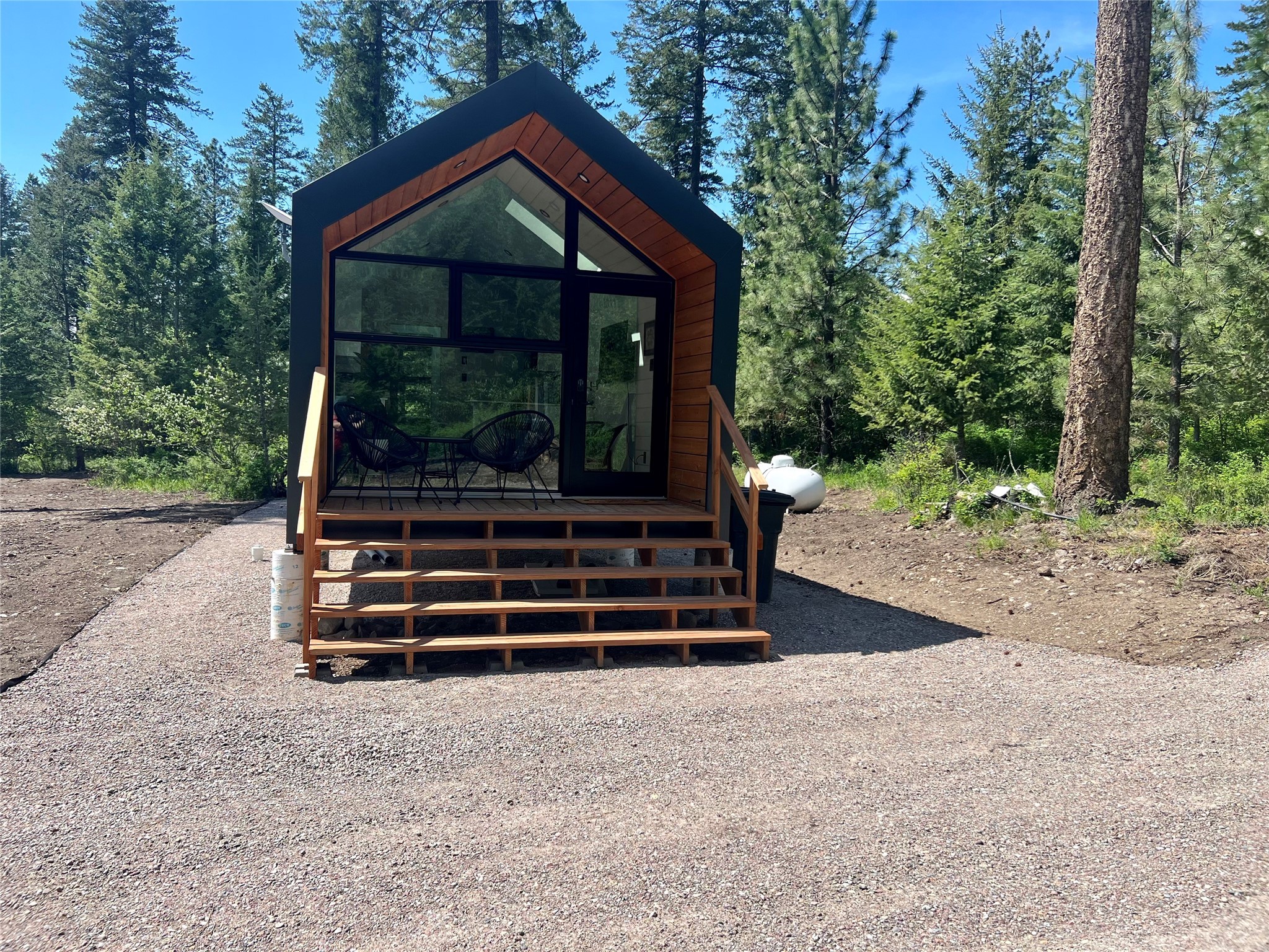 Beautiful Tiny Home on 7.5 Acres with a Seasonal Creek

Escape to the serene beauty of Western Montana and experience the joys of small-scale living with this stunning tiny home nestled on 7.5 acres of natural splendor. Tucked away in the heart of nature, this property offers a peaceful retreat that's both cozy and spacious in its own unique way.

Step inside the open living area where the boundary between indoors and outdoors seems to blur. Large windows frame breathtaking views of your own private wilderness. The compact yet well-equipped kitchen boasts modern appliances, clever storage solutions, and a dining area for intimate meals.

Step outside onto your private retreat and enjoy your morning coffee as you listen to the seasonal creek. Soak in the cedar hot tub as you watch the big sky. Mollman creek meanders through the property, offering a soothing backdrop to your daily life. Enjoy peaceful walks along the water's edge or simply relax to the sound of nature. Property also includes RV electrical hookup. Schedule a showing today! Call Amber Isbell 406-951-0849 or your real estate professional.
