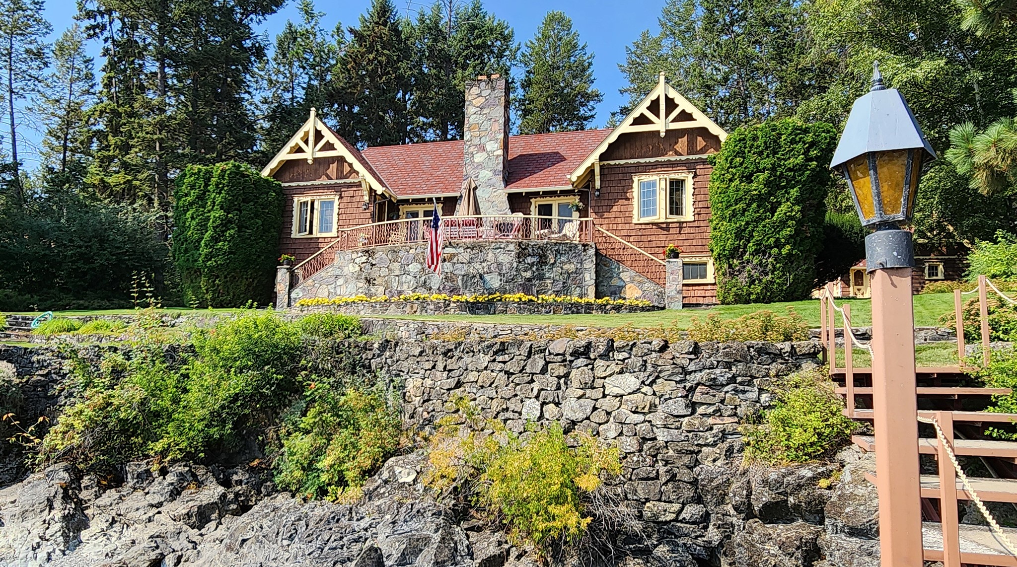 Generations, since the 1960s, have enjoyed this recognizable "Gingerbread" house along the westshore of Flathead Lake. This historic home sits on 3.7 acres and 378 feet of frontage spread over multiple lots (see survey). Very private, the circular driveway is bordered by long standing rockwork and landscaped grassy lawn. Enter into a large Living Room with rock fireplace. As you discover the home, you'll notice all the carved woodwork detailing, wood floors, and historic lighting & textiles. The S wing has 2 Bedrooms and full Bath. The north wing has the Kitchen and Dining Room, another Bedroom with attached 3/4 Bath. Downstairs is a Bedroom, Storage and Utility Room. Facing the lake is a full-length stone patio with outdoor fireplace to enjoy the sunrise and Alpenglow in the evening. Amenities include dock, dble garage, laundry shed. To west is the interior knoll of Caroline Point for guest house and exploring. Call Scott Hollinger at 406-253-7268 or your real estate professional.