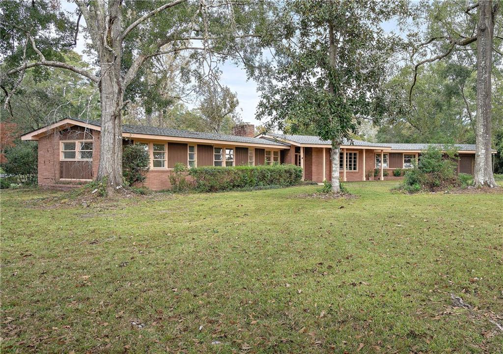 Mid-century modern charm tucked into the haven of historic downtown Covington awaits you! Situated on an expansive lot measuring ¾ acre, it's within walking distance to top-notch schools, shopping and fun. You can’t help but smile looking out the picturesque crank awning windows throughout. Ample living space is flexible and a screened back porch under beam with an outdoor fireplace provides a perfect memory-making backdrop. Put your own touches on this fabulous beauty and come home to perfection!