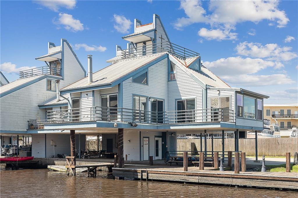 Gorgeous panoramic view of the Tchefuncte River from this private end townhouse unit on the river has lots of dock & a boat slip for  convenience. There is a covered BBQ/Party area. Amazing upper balconies on 2nd & 4th levels. Great room & dining room w/ sliding glass doors for a spectacular panoramic view of the wide bend in the river. Sunroom off of master bedroom & dining room for more viewing. Conveniently located near the fun of Madisonville & Mandeville with a quick boat ride to Lake Pontchartrain.