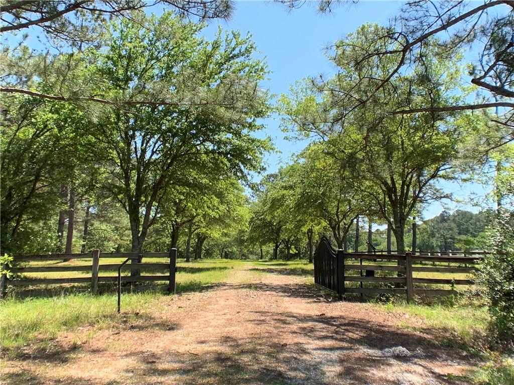A gated meandering oak lined drive welcomes you to 35 stunning rolling acres in Chenel Farms. 2 bed/1 bath cottage with a separate studio, both overlooking a gorgeous 10 acre lake. Enjoy horse trails, natural Louisiana flora and fauna. Huge barn currently being used as an equipment barn with a bath and office that can easily convert to a horse barn.