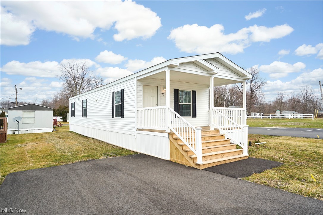 Manufactured / mobile home featuring a front lawn and covered porch