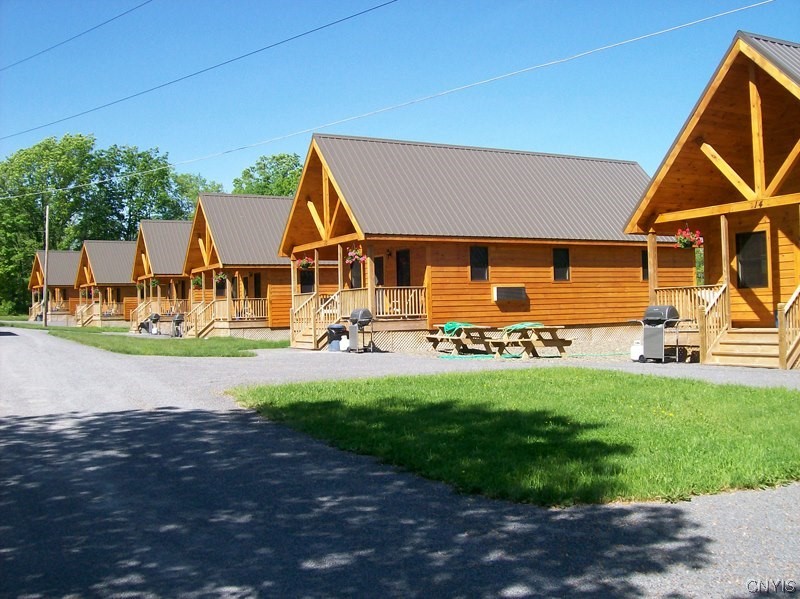 Grand slam opportunity with this spectacular offering at Chalet Village, located across the street from Cooperstown Dreams Park, about 5 miles from the baseball Hall of Fame and Otsego Lake. Chalet Village offers 16-2 bedroom custom-built Chalets with a heated pool, wifi, clubhouse, and office building nestled on just under 7 acres. (SF Shown is approximate and reflects a combination of all chalets). If you are seeking an excellent investment opportunity in the hospitality sector, this is a must-view.  Each unit is meticulously maintained. Very well-run operation with an excellent reputation.  The clubhouse, heated pool, and outdoor basketball court offer ample recreational activities while clients enjoy the excitement of the baseball season. It sells out every year during baseball tournament season, and the season runs for 16 weeks, allowing you to capture in a very short period what much larger operations produce in a full year. With the owners only renting during baseball tournament dates, additional income can be had expanding availability to the shoulder season of the summer. Don't miss this perfect pitch for a home run!