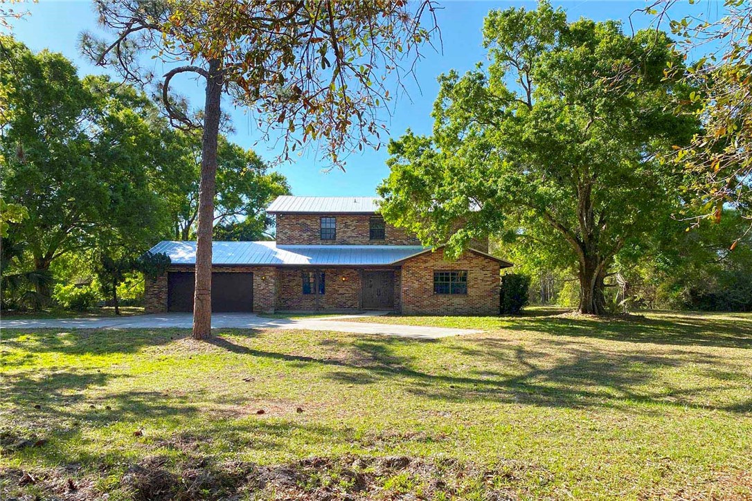 Stately brick home w pool on 5 acres with an Old Florida charm! This 3 bedroom, 3 full bathroom home w 2 car garage offers privacy & serenity overlooking the numerous majestic oak trees & large pond. This solidly built home features a 2019 metal roof, double sided wood burning fireplace in living & dining rooms, spacious layout w large bedrooms & walk in closets.. some updating needed. Artesian well on property!
