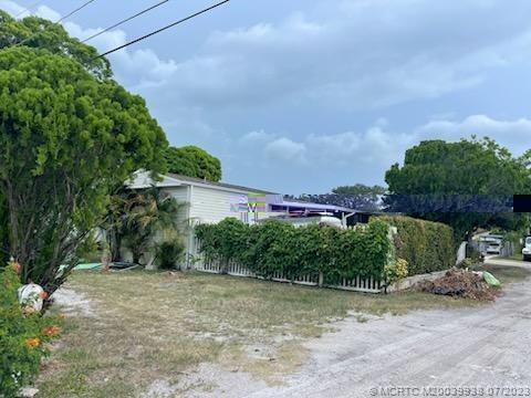 YOU OWN THE LAND, NO HOA!!! Great investment opportunity in Hobe Sound! What a location, close to gorgeous beautiful beaches, world class golf, and a short drive to I-95, the Florida Turnpike and Palm Beach International airport. The property is divided in two. Each side has its own gated entrance and fenced in yard.  On one half there is a manufactured home 2/2 split floor plan with large screened in porch, living room, dining rm, laundry rm with full size washer & dryer.  This private, corner  fenced in lot has a firepit, BBQ grill and room for all your toys!  The other side is a 1bed/1ba 5th wheel slide out with 2 designated spaces, large fruit trees and only a block and half west of US1 in a quiet neighborhood. Bring your RV's, truck, motorbike and pets welcome. Currently rented on month to month lease. Great investment for South Florida Living!
