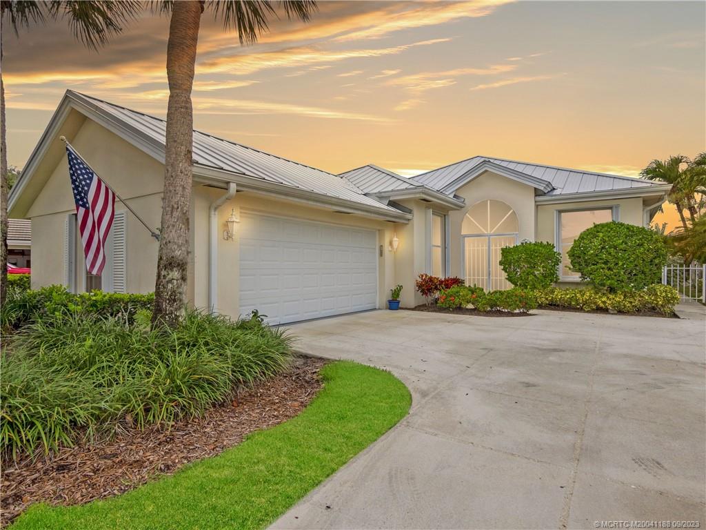 You can feel the love put into this home in the Palm City gated community of The Meadows.  An original DiVosta "Hampton" model with ceilings approaching 10 feet, one can feel a sense of warmth, coupled with some sensible updates.  Perfectly located in the Greenwich neighborhood which is in close proximity to the main entrance.  Inside, natural wood floors invite visitors and family alike to enjoy the serenity.  Main and guest baths have been recently updated in a modern, coastal palette.  New AC, hot water heater, garage door, and metal roof in 2016-2017.  Hurricane panel protection and poured concrete construction adds to the peace of mind.  Outside, enjoy a lush walking path garden, bougainvillea adornment, and a direct lake view.  The Meadows remains one of the most sensible options in Martin County, with gated security, resort pool, tot lot, bocce, sidewalks, tennis/pickleball, and more.  Front yard maintenance, high-speed internet, and cable included in community fees!