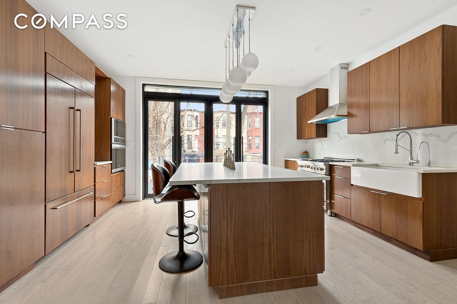 Gut-renovated and completely redesigned to combine modern style with classic accents, 451 Hancock Street is a stunning two-family, three story brownstone in the heart of historic Bed-Stuy, Brooklyn.

As you enter the owner's duplex on the parlor level, you're greeted by a light and lofty living space with new white oak floors and flooded by natural lighta warm and hospitable place to come home to, with a powder room and plenty of closet space. But in truth, the kitchen is the main event here. Wide and welcoming, it spans the entire width of the home, capped on the northern end with tall glass doors that open right onto a large outdoor deck (dining al fresco, anyone?). Light marble countertops and a large porcelain farmhouse sink contrast with richly-stained custom cabinetry, as stylish pendant lights dangle above a large center island. The breakfast bar is the perfect place to have a nightcap or casual dinner, though there's more than enough room for a dining table. Featuring all-new applianceslike a stainless steel gas range with vented hood, in-island dishwasher, and an extra-wide 42' refrigerator with French doors paneled to match the cabinets that line the entire roomthis kitchen is enough to satisfy even the most demanding home chef. You've even got a microwave and wall oven combo, for that little bit of extra heat when extra heat is what's called for.

Following the stairs down to the garden level, you'll find two spacious bedrooms. The main bedroom features large dual closets and a doorway right out to your private backyard (also completely renovated, surrounded by wooden fencing and edged with rich garden soil). The en suite, five-piece bathroom has a shower, bathtub, toilet and double vanity, with a high-tech Bluetooth mirror for music in the morning and radiant heated floors. The secondary bedroom feels anything but secondary, with more than enough space for a king bed and an en suite bathroom of its own, also with heated flooring. One final flight down is a masterfully finished basement, with unusually high ceilings and half bath, and laundry room with full-sized washer dryer and wash sink. It's the perfect spot for a home office, rec room, workout studio, guest suite, storage space, or all of the above.

Upstairs on the third floor, your tenants (or houseguests) will enjoy a totally renovated, totally spacious 2 bedroom, 1 bathroom apartment, complete with all-new kitchen appliances and in-unit washer dryer. The main bedroom is more than large enough to accommodate a king bed and wit. The secondary bedroom is just right for a home office, nursery, or guest room. And considering the finishes and location, it won't be long before it's generating revenue.

Speaking of location, 451 Hancock St is in the middle of everything. The Brooklyn Waffle House isn't even half a block away, and will quickly become your go-to for breakfast or lunch (try the chicken and waffles, they're amazing). Saraghina, Peaches, Mama Fox, Luntico, Chez Oskar, Brooklyn Beso, and so many more eating and nightlife establishments are just minutes away from your front door. Bounded by the energy of a diverse community, it's close to Kosciuszko Pool, Herbert Von King Park, and several neighborhood playgrounds and community gardens. Nearby subway lines include the A/C at Kingston-Throop and Utica Avenues.