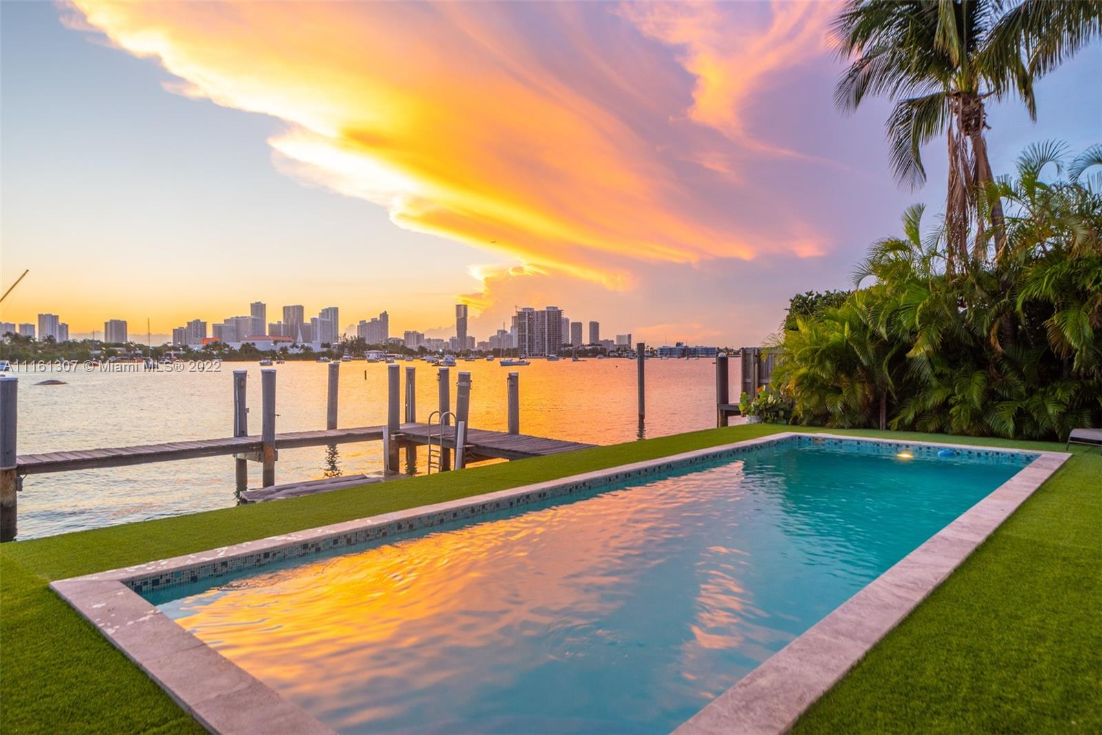 Step Inside With Me! Located on the Western tip of Palm Island, this waterfront home emanates character and charm while showcasing the most desired view in town - the Miami Skyline. Hosting 4 beds, 3 baths, this efficient floor plan leaves room for expansion. The primary suite extends into a lounge area overlooking the breathtaking water and city views. This home is finished with travertine and original wood flooring. Entertain under the covered porch or in the open lounge space by the heated pool. Ideal for a boater with 79 feet of wide water frontage and new dock. Recently renovated, this home is complete with a new roof, driveway, gate, and plumbing and electric redone. Palm Island is a prime location in close proximity to South Beach and Downtown Miami.