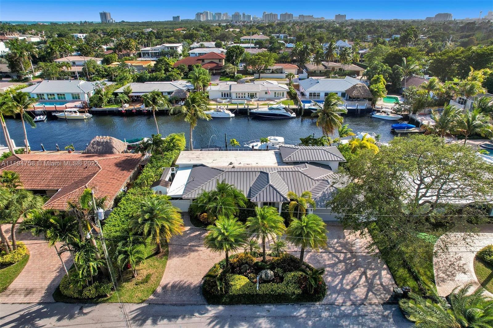 Modern Coral Ridge waterfront home with spectacular views of the coast. This boaters paradise includes impact windows & doors, porcelain 4x4 flooring, open kitchen & living areas overlooking the pool & canal, quartz countertops, long bar with designer backsplash, Viking appliances, LED lighting throughout, stone wall with LED electric fireplace, & custom lighting. The master suite includes direct water view with large walk in closet and bath. Exterior features new awning for carport, large 2 car garage with epoxy flooring, metal roof, 24x12 covered patio with high ceilings, light up bar with ice maker & beverage cooler, 11 car parking, pavers, 100' seawall, 30 ft dock, 2 dolphin pilings, & substantial tropical landscaping. Walk to the galleria mall, Bayview school and minutes to the beach.