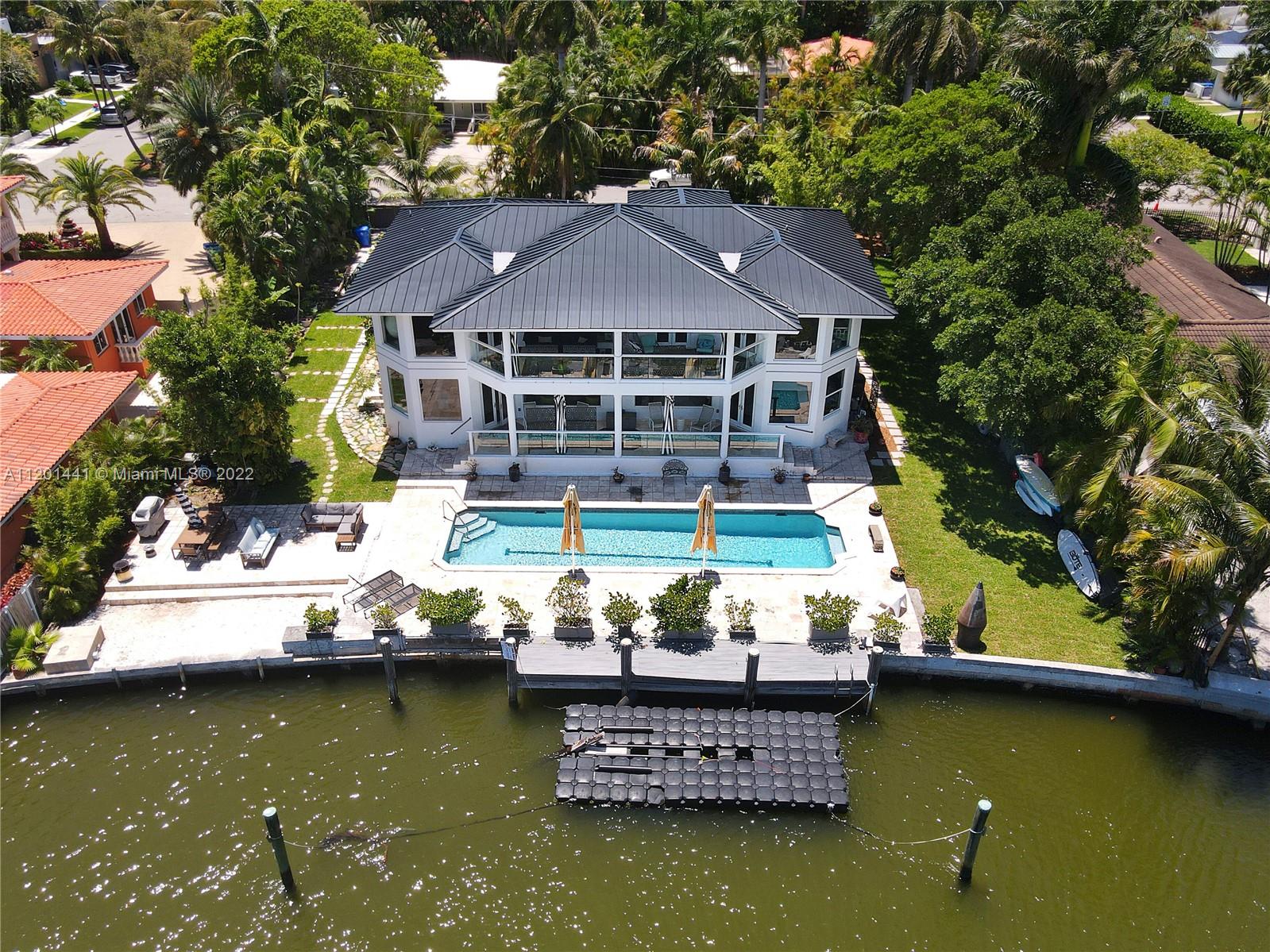 Attention boaters. This grand 7 bedroom, 5 bathroom, modern masterpiece sits on a 17,717 sf lot with 120' on the deep water, just 500 feet in from the wide bay with wide water views. Enter the front gates to a huge car park, 2 car garage, and an impressive 2 story home with a new metal roof, impact windows and doors, new a/c, white porcelain tile throughout, volume ceilings, large Italian kitchen with DACOR appliances, large stacked back porches to enjoy the water views, waterfront pool and dock. Home has Volume ceilings, second floor family room, and  French doors that open to a huge master suite with glass walls bringing the expansive views to you. Bring your fussiest buyers.