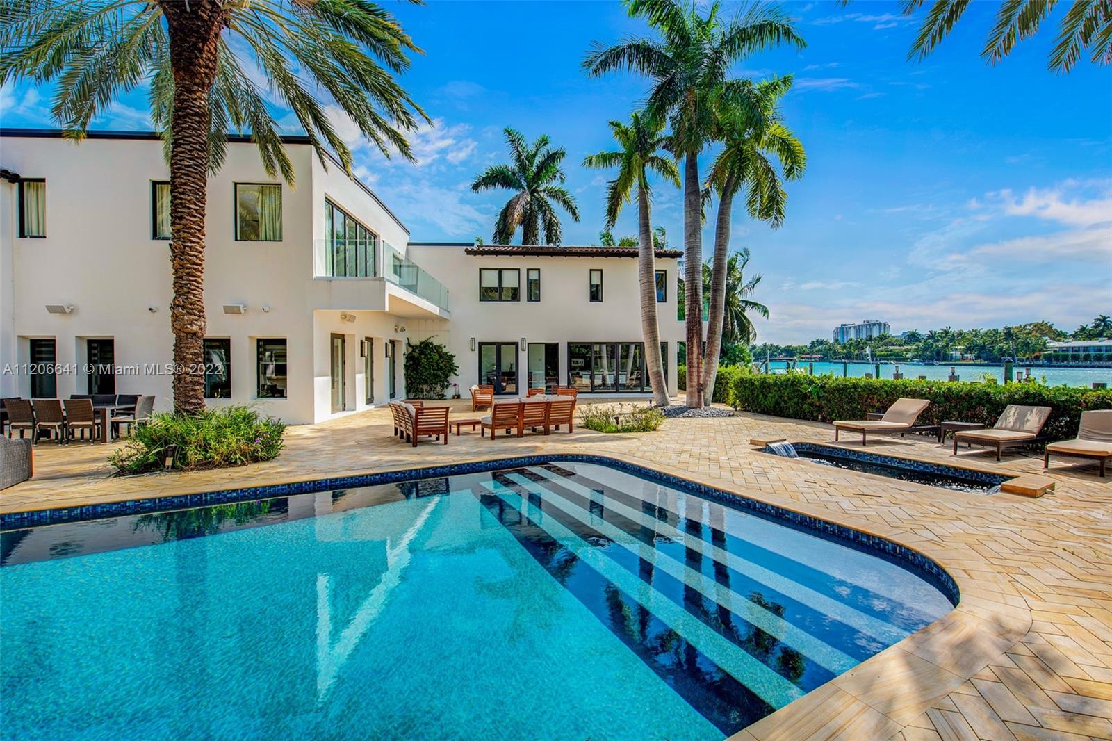 Architecturally stunning waterfront estate with open water views on the prestigious North Bay Road. Sitting on an expansive 27,000 SF lot, this two-story 10,114 living SF residence was built by MV Group USA and is designer furnished, featuring sleek, luxurious details throughout. Offering 100 feet of prime water frontage, you'll enjoy a marvelous outdoor area with a large pool, jacuzzi, spa, dock, and boat lift, no fixed bridges to the bay, and lush landscaping for ultimate privacy. Renovated in 2015, this 11 Bedroom / 12.3 Bathroom estate boasts an enviable sophisticated lifestyle complete with a guesthouse, 3-parking garages, gym, office, master suite with balcony, and more!