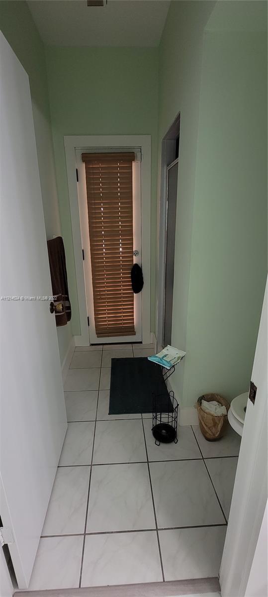 Hallway bathroom with privacy door to shower/toilet and exit to covered patio/pool