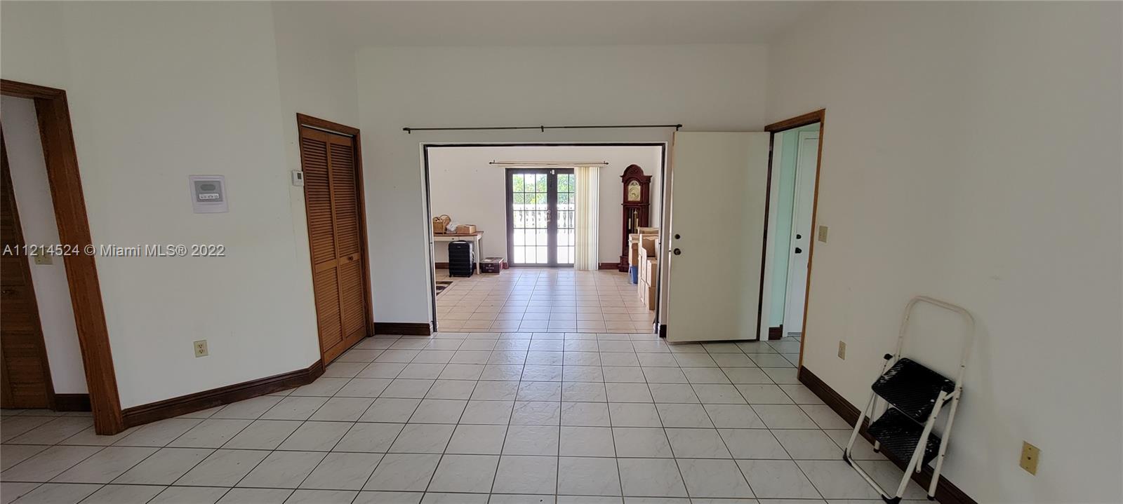 2nd Floor: Master Suite looking rear to living area and doors out to open balcony patio