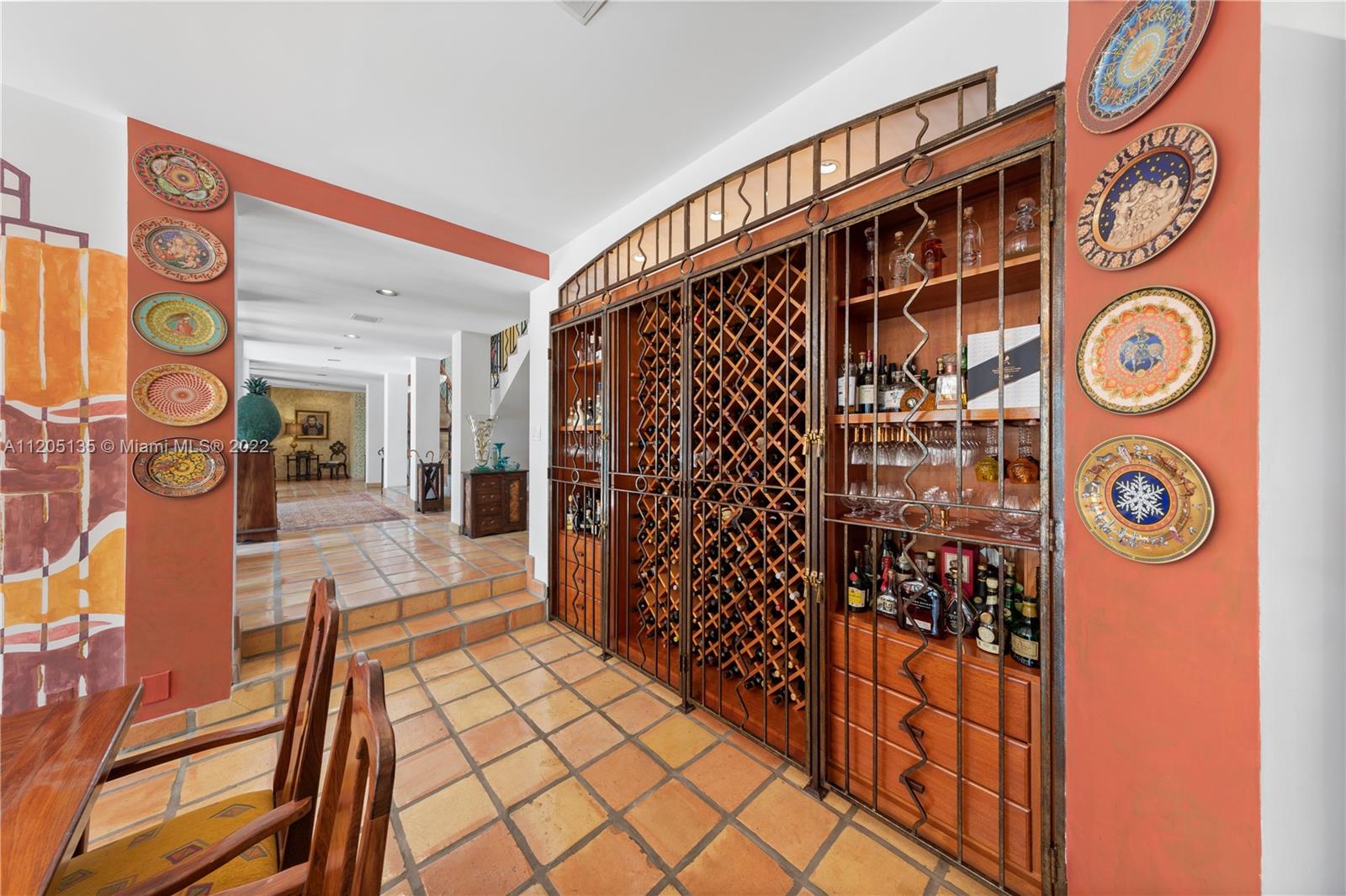 126 bottle mahogany wine cabinet w double liquor cabinets, built in w/ drawers and enclosed by custom signature ironwork seen thru out the estate.