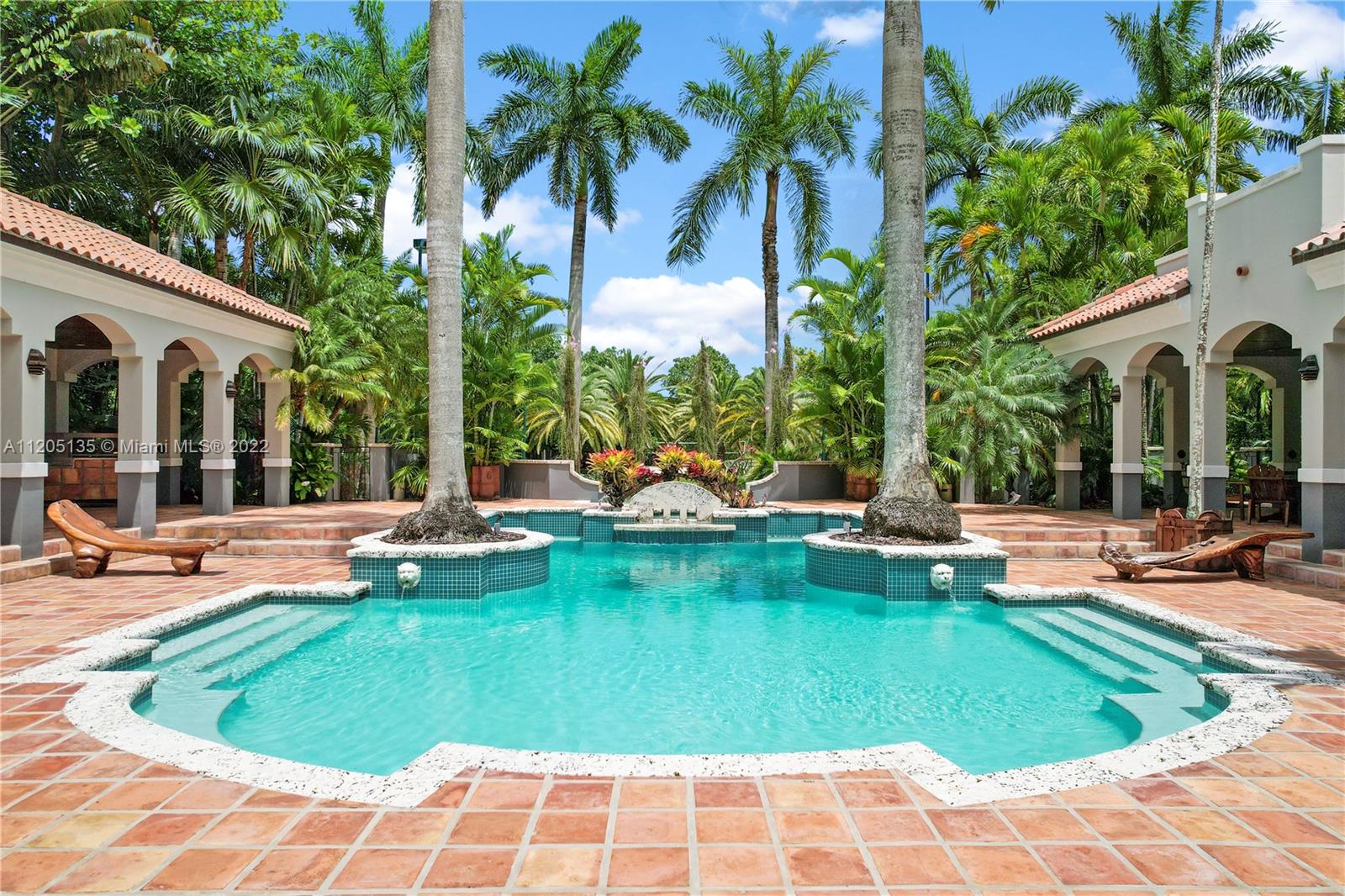 Pool view from great room flanked by lanais and covered walkways.