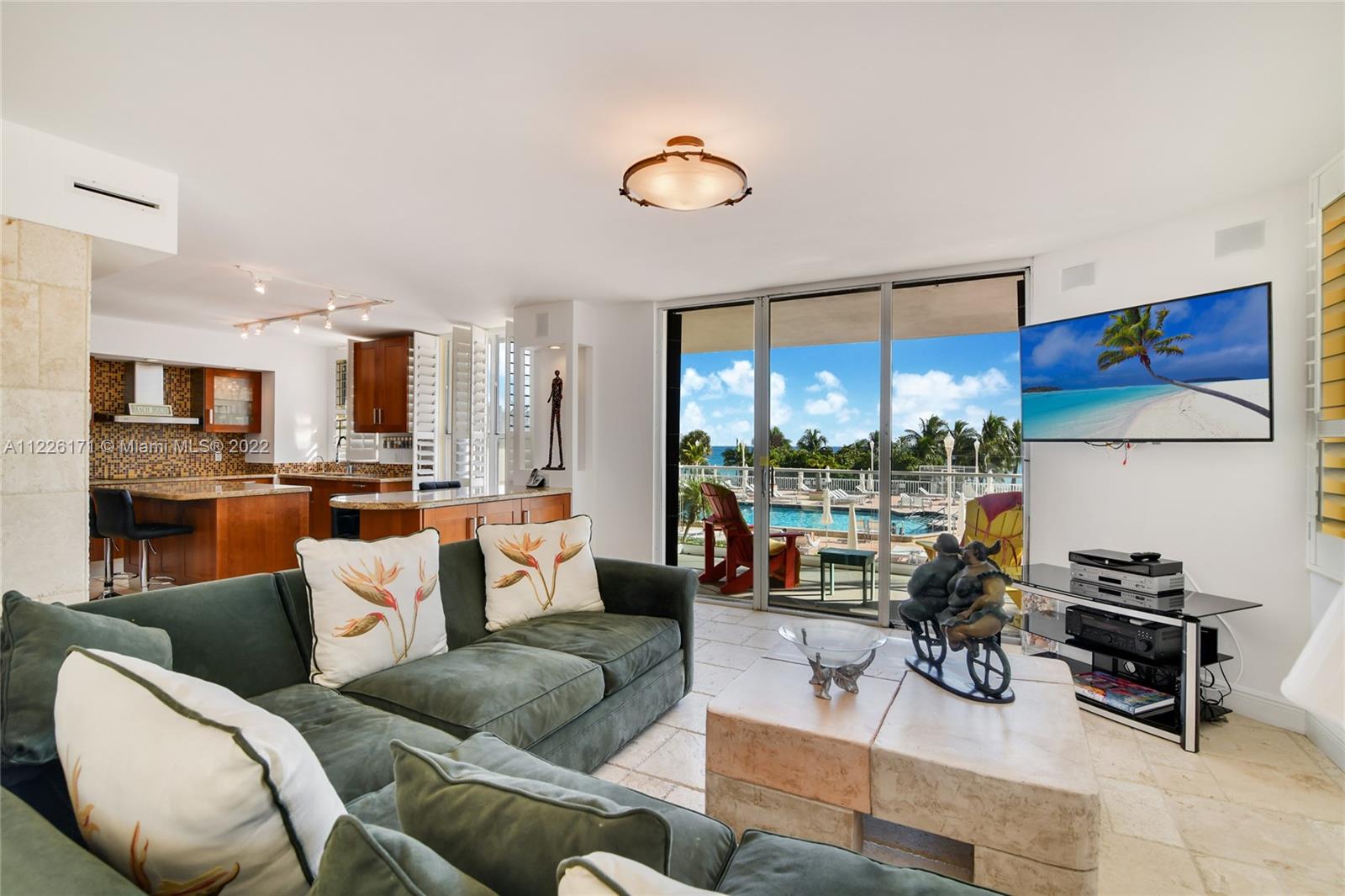 Living room and kitchen looking the ocean and the pool