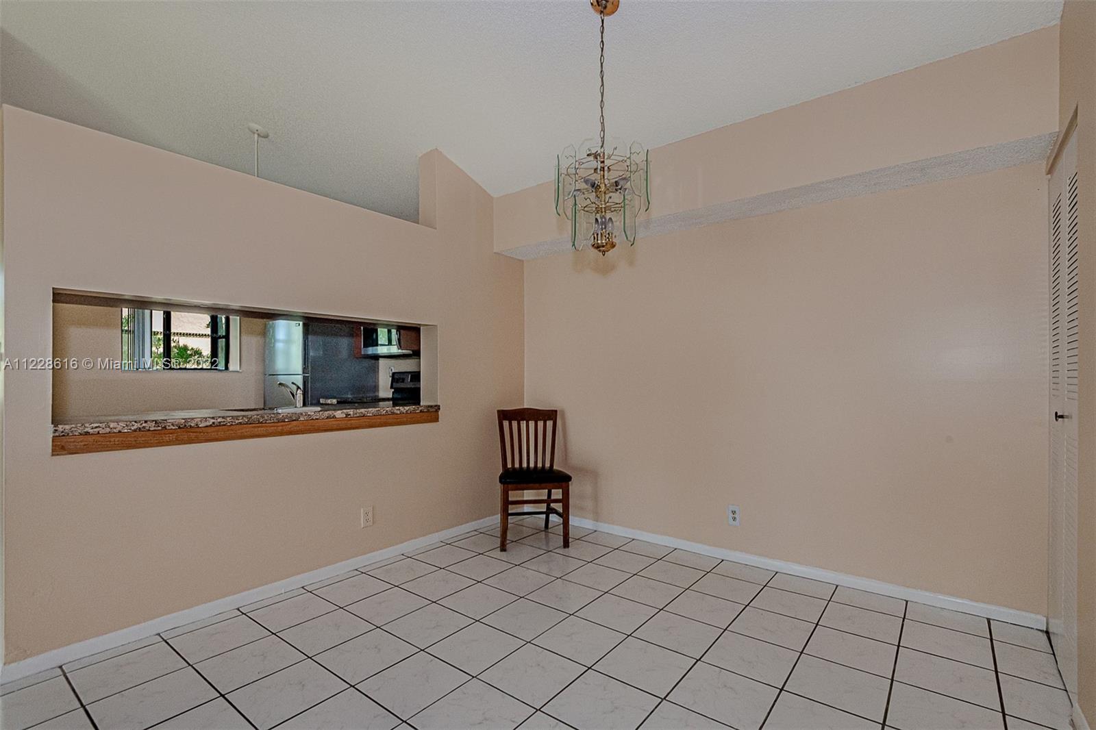 The dining area showing the kitchen pass through.