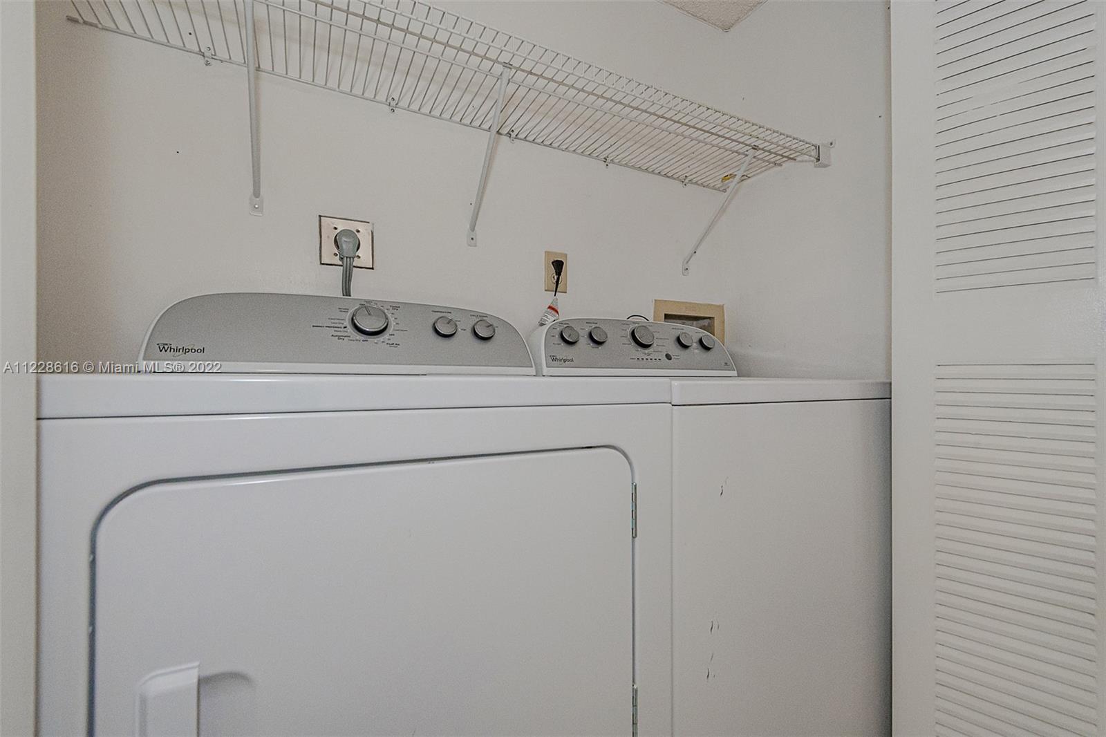 The full size washer & dryer are behind bi-fold doors in the hallway to the bedrooms.