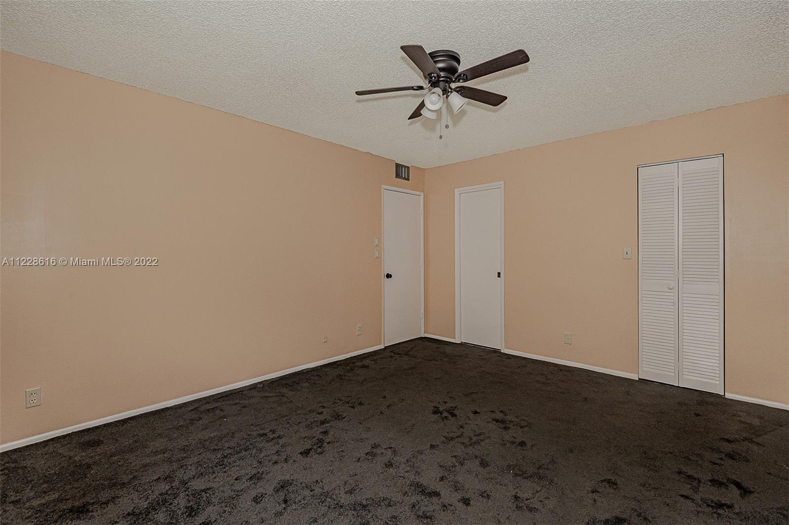 The master bedroom back to the entry door, bathroom door, and walk-in closet door.