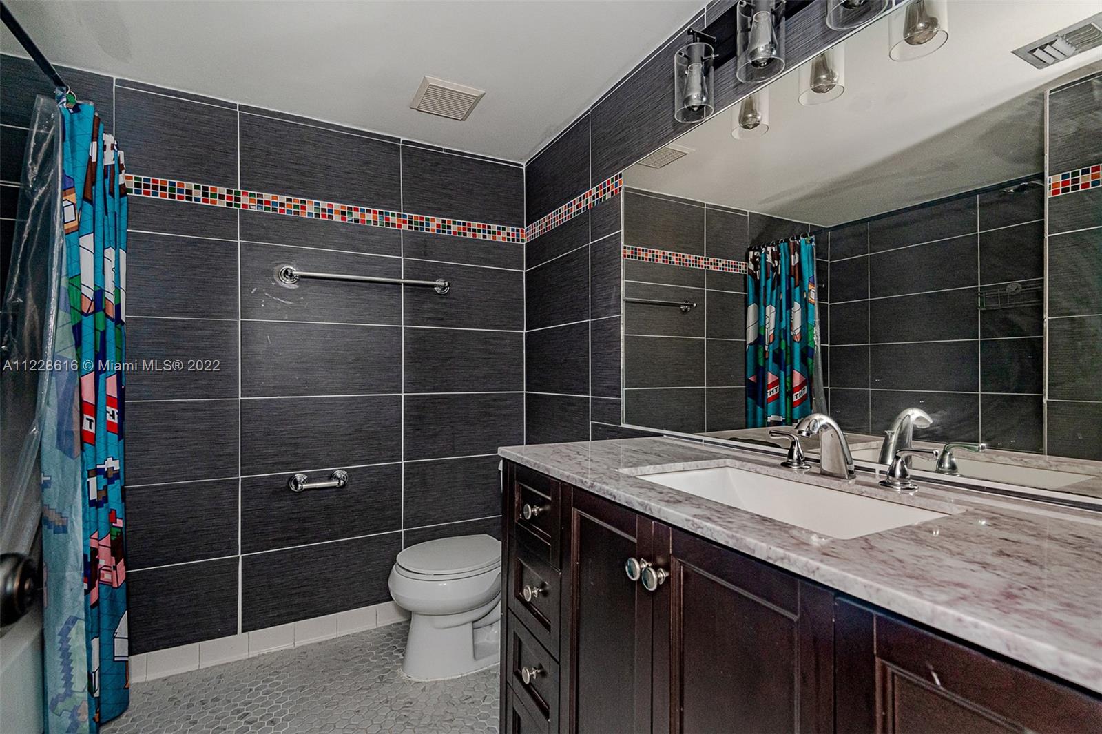 The hall bathroom with a large vanity & mirror