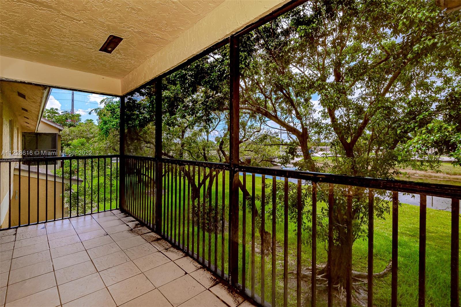 The screened porch has a view of the green space and water for a peaceful place to relax.