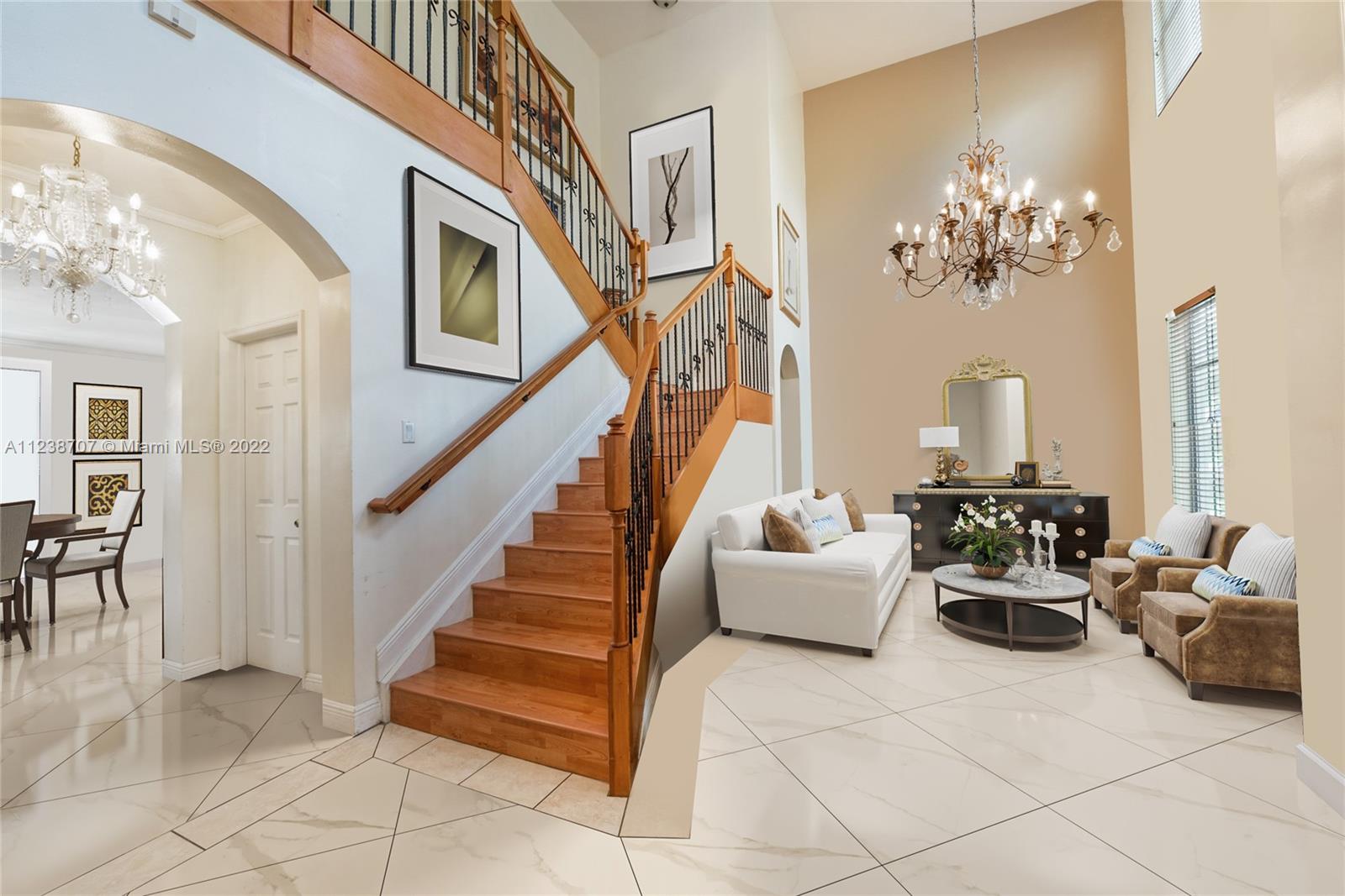 Grand staircase, volume ceiling. Can be used as a formal living room, a family room or a formal dining room (staged image)
