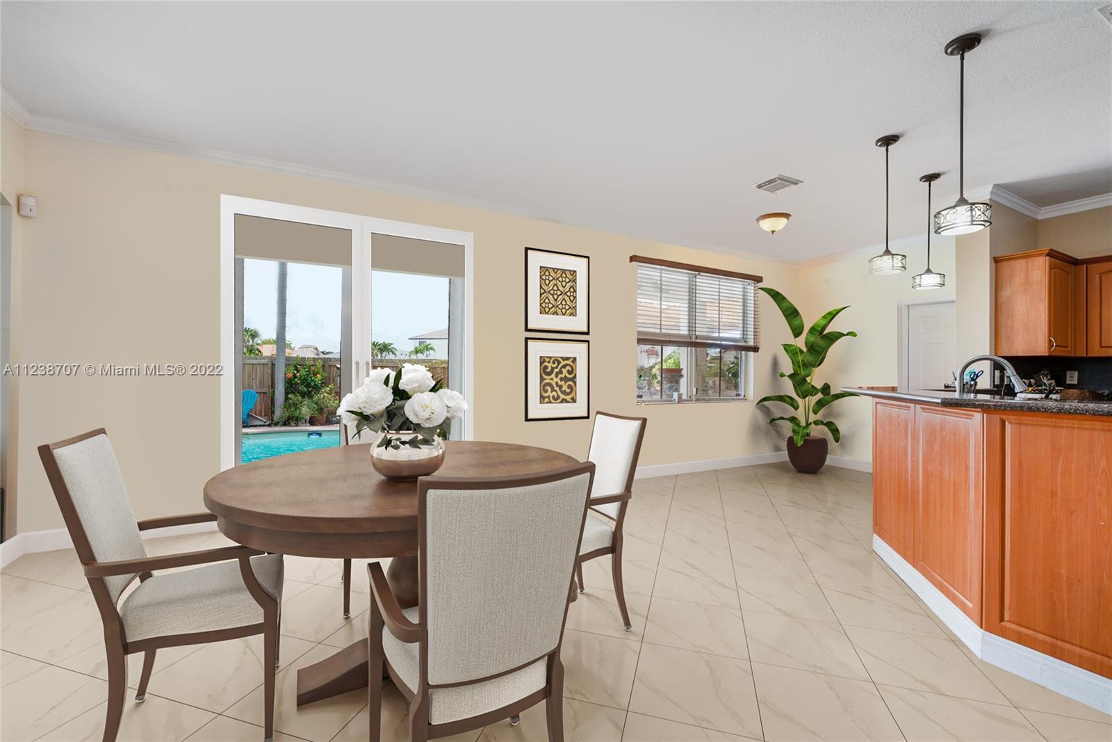 Kitchen with breakfast area - direct view and access to pool/backyard. (staged image)