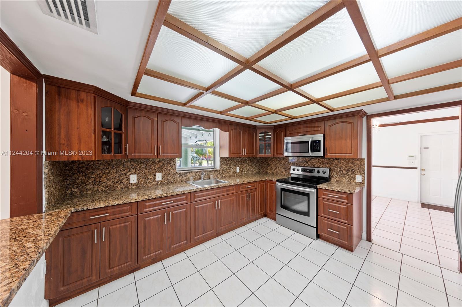 MAIN KITCHEN OPEN OVERLOOKS THE POOL/PATIO AND OPENS TO FAMILY ROOM