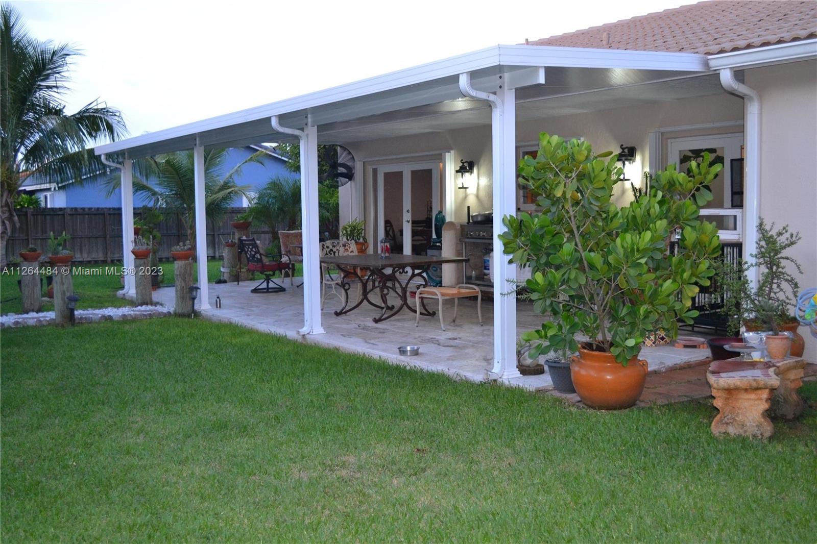 Beautiful back porch with travertine flooring and 2 double impact doors.