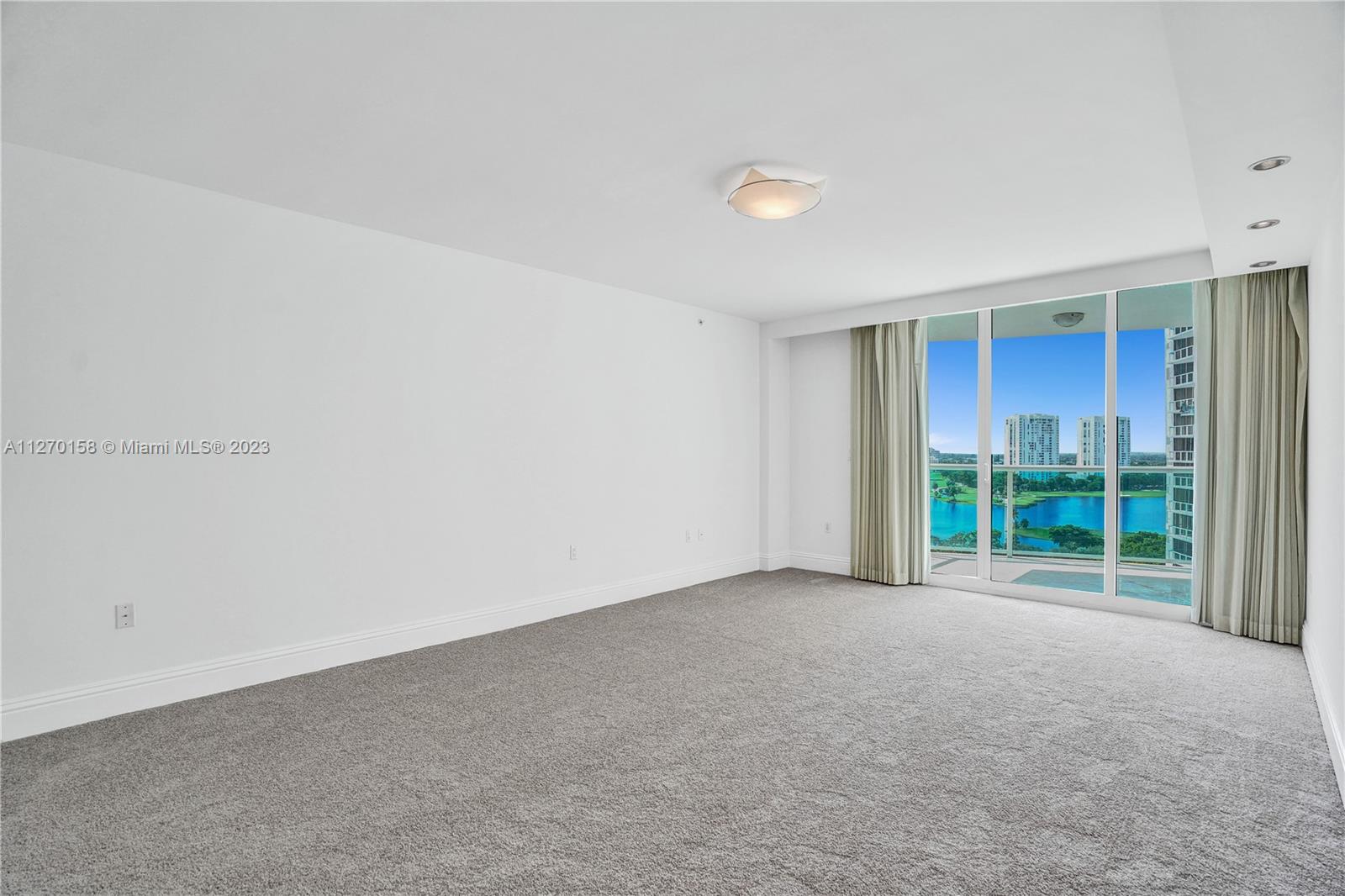 Spacious master bedroom with lake and city views.