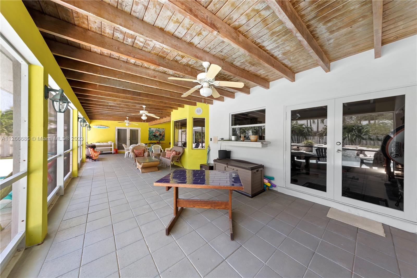 PARTY PATIO COVERED & SCREENED W/ T&G CEILINGS ALMOST THE LENGTH OF THE HOUSE. 6 SETS OF FRENCH DOORS LEADING TO THE PATIO, ALSO WITH HURRICANE SHUTTERS YOU CAN CLOSE IN THE ENTIRE PATIO