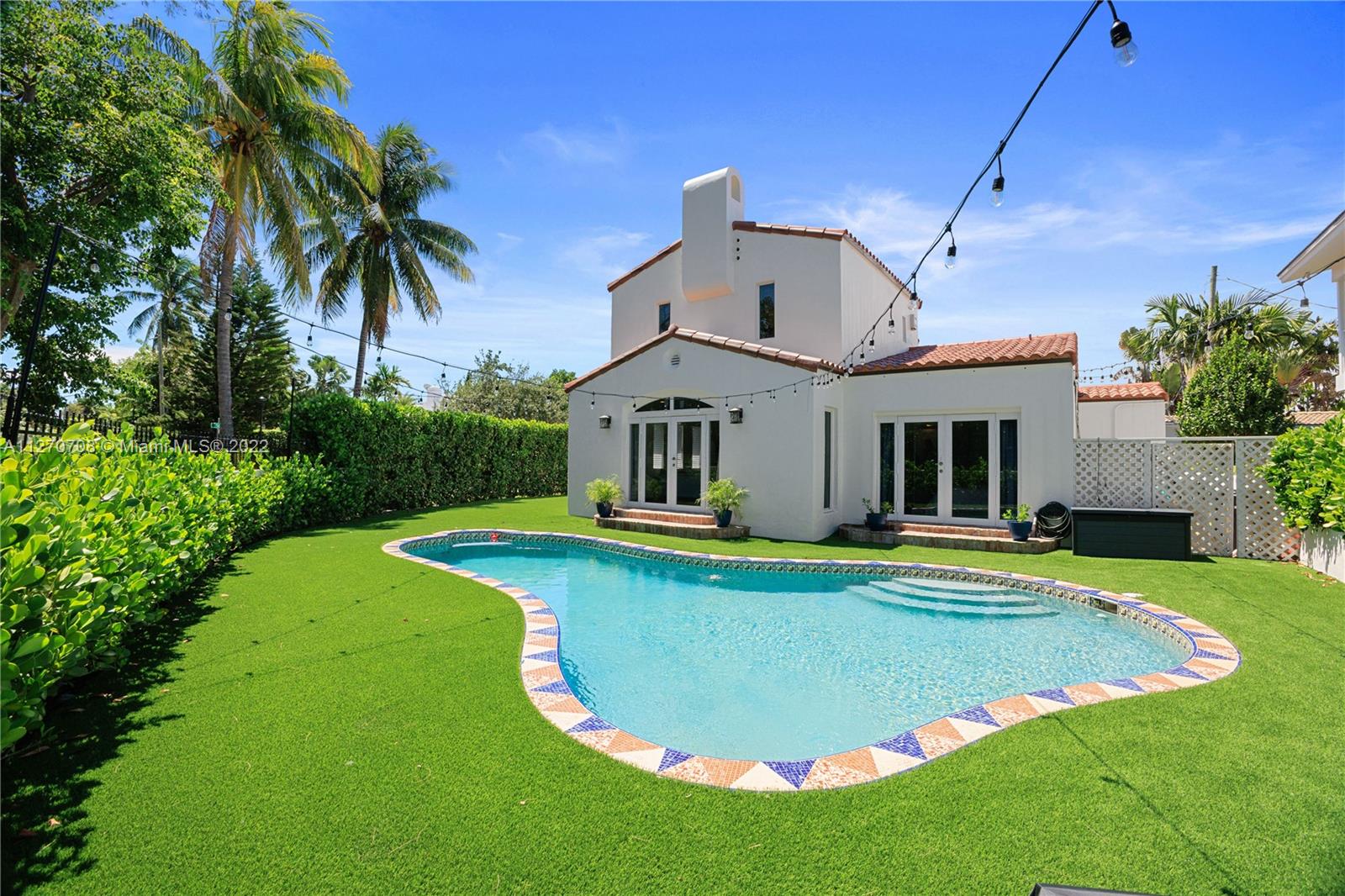 Back and side view of house with new artificial grass