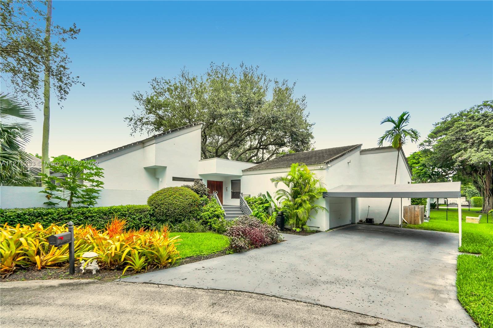 Mid-century modern Palmetto Bay residence is grounded by mature oak trees and takes full advantage of its surroundings. Nestled on a cul-de-sac, this angular beauty takes “bringing the outside in” to the next level, wrapped around an atrium of lush foliage with decking built to accommodate existing oaks. Vaulted wood beamed ceilings in the main living areas mimic the nature outside. Walls of windows usher in the light. Kitchen overlooks patio and pool, perfectly placed for indoor and outdoor entertaining. An open loft with spiral stairway overlooks an expansive family room area featuring a fireplace and bar. The main living area and bedrooms have new plank flooring. Situated on a secluded lot, the home rims navigable waters and has a private boat ramp. A unique find in a prime location.