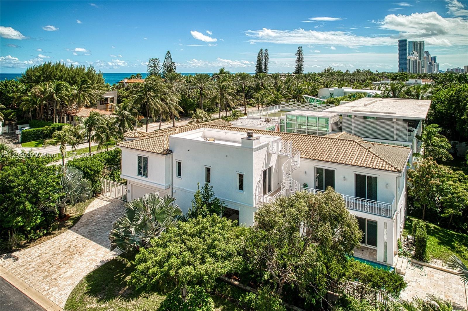 It will be hard not to fall in love with this state-of-the-art, 2-story house located just a few steps from the beach. It’s the perfect blend of sophisticated and gorgeous; built on the edge of modern luxury, this functional home is perfectly enveloped in light and comfort. The house has six bathrooms, five bedrooms, and two deluxe master bedrooms. The central living area is simply stunning, with a massive open space with a vaulted ceiling. The beautifully modernized gourmet kitchen is bathed with natural light from its floor-to-ceiling windows. The swanky entertainment patio has an infinity pool, a summer kitchen, a sauna, and a roof sun deck. All this luxurious beauty is in the small upscale community of Golden Beach, which is gated with a private beach and has its police department.