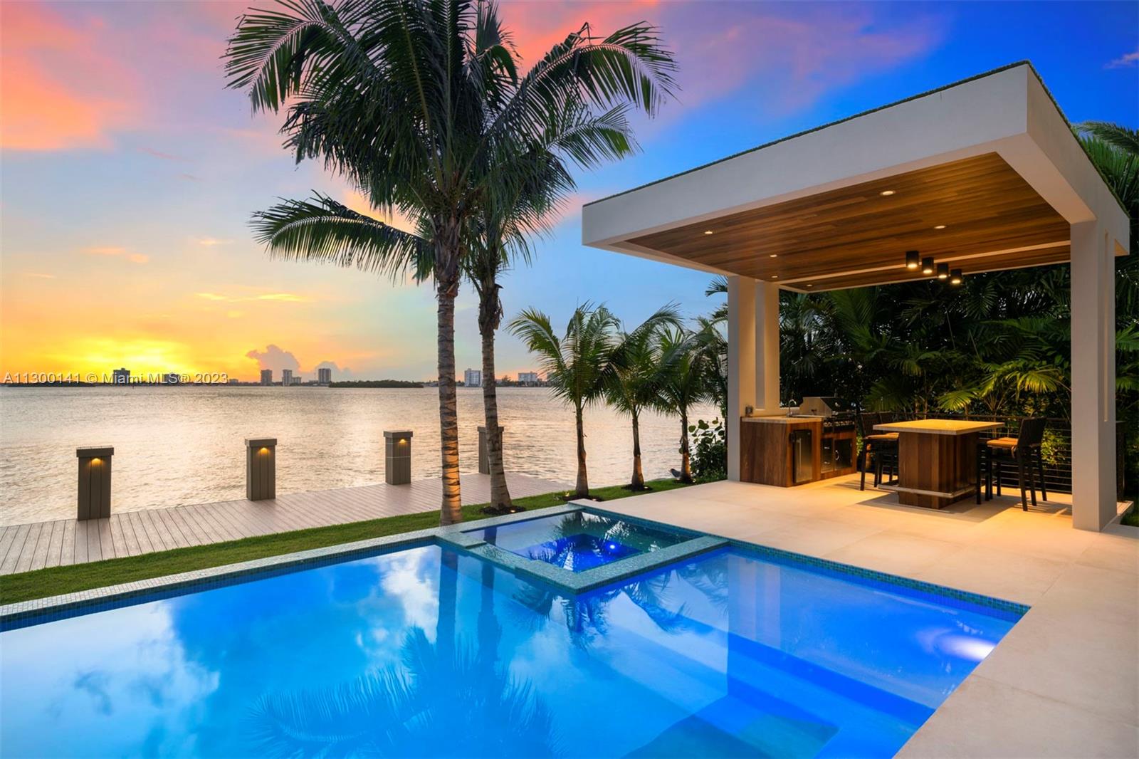 This tropical modern masterpiece w/ architecture by Choeff Levy Fischman, interior design by CBDesign, developed by Gamma Construction, evokes the essence of Miami Beach sophistication. Enjoy unique open water & Indian Creek golf course views from this waterfront marvel where the indoors flow seamlessly to the outside. Modern yet functional design, this estate is an entertainer’s dream w/ 9,000+ SF & 80’ on the water. Features: 2 full high-end kitchens w/ Sub-Zero & Wolf appliances, elevator, gym, wine room, 2 family rooms, home automation, natural herringbone wood flooring, walls clad w/ exotic materials, infinity edge pool, spa, private dock. Enjoy breathtaking views from floor-to-ceiling walls of glass & exceptional craftsmanship all moments from world-class dining, shopping,& beaches.