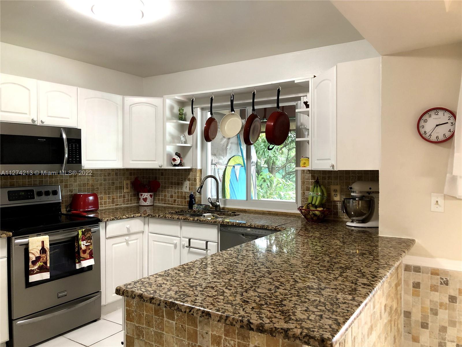 Bright and sunny Kitchen has stainless steel appliances (microwave, refrigerator, smoothtop stove, dishwasher) and Granite countertops with Backsplash throughout. The Kitchen features a lovely view of garden from window.