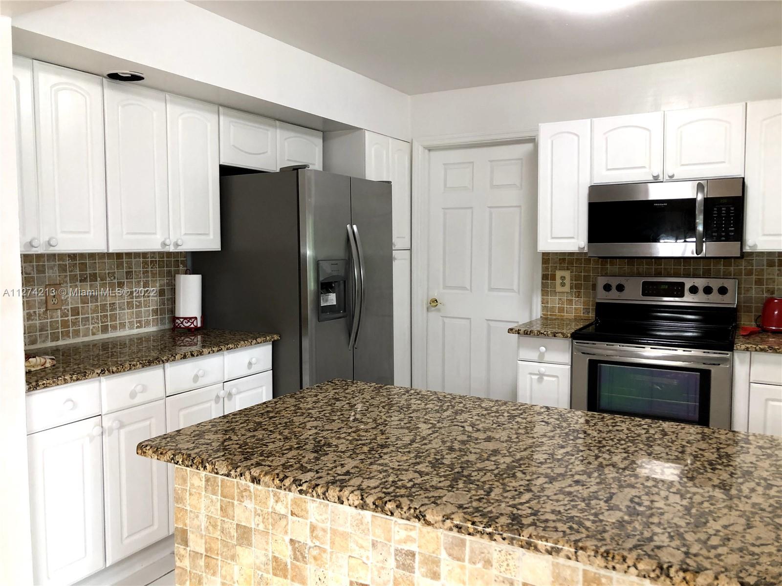 Kitchen has plenty of cabinetry and a pantry.