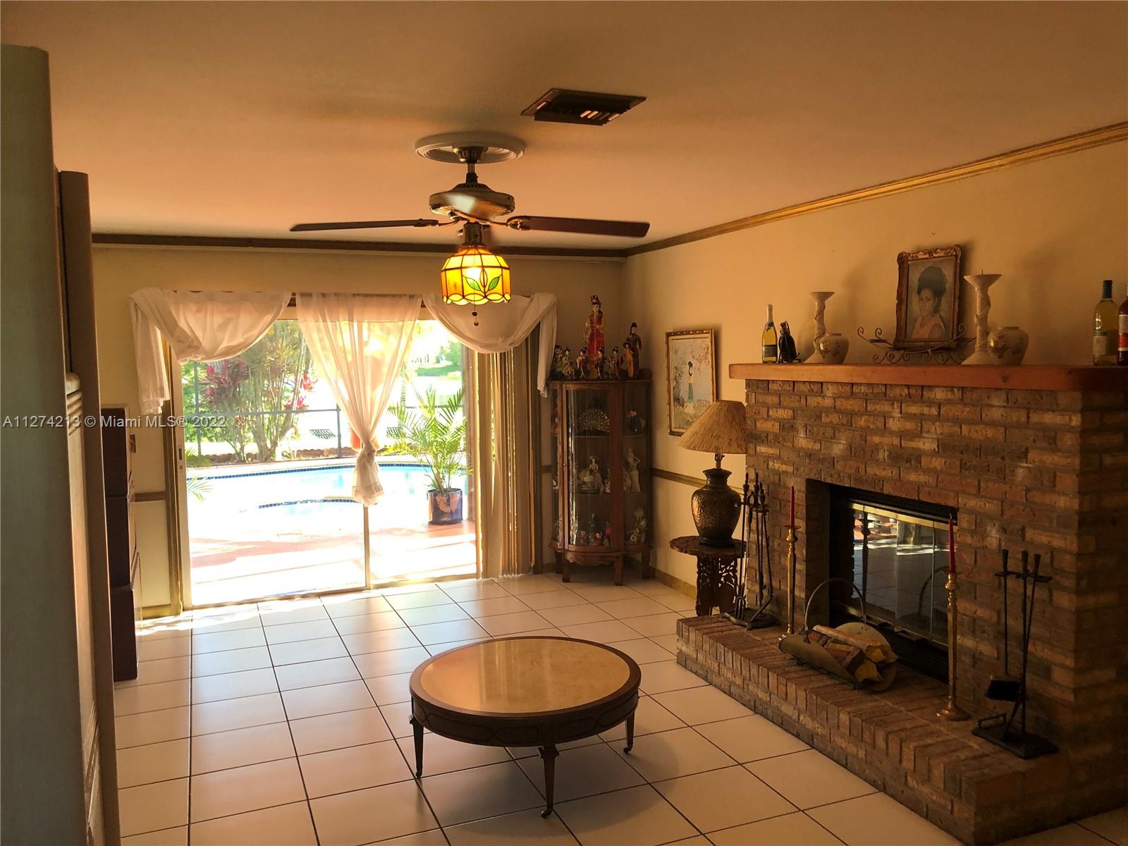 Large and beautiful Brick Fireplace in the Family room, ceiling fan and a fantastic view of greenery, the pool, and lake. This is a great room to spend time with the family, enjoy watching sports, a great movie, or just take pictures around the fireplace especially during the holidays!