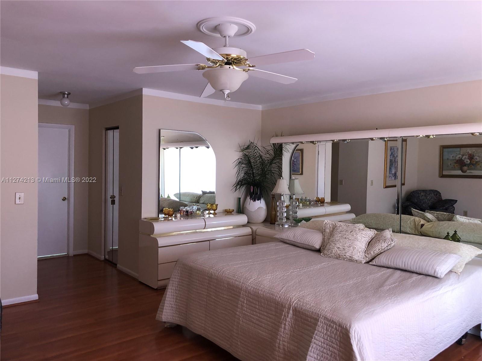 Spacious, bright, neutral color Master bedroom with ceiling fan and molding throughout.