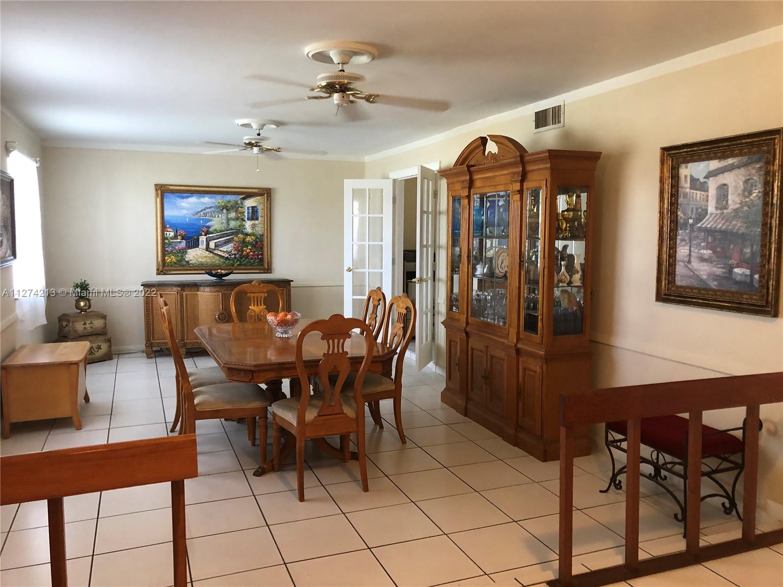 Large and airy Living Room with two ceiling fans, ceramic tile floors, two impact resistant windows, and French doors leading to home office (formally the Dining Room). Use this living room for special occasions or an entertainment room.