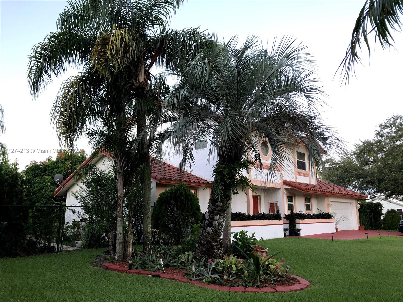 Side view of house. Privacy fence and hedges.