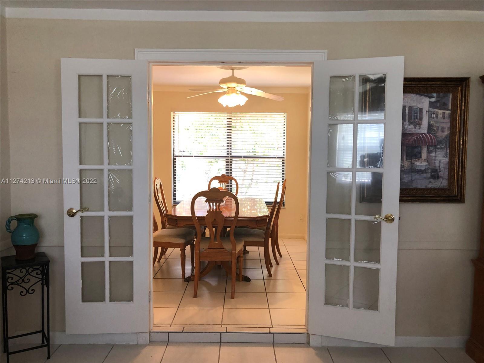 Beautiful French doors in Living room lead to Formal Dining Room (currently used as home office) with ceiling fan overlooking garden. This room can be used as den or 4th bedroom - has a closet for storage.