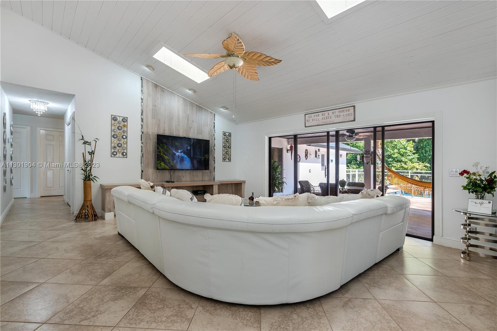 Ample open concept kitchen with central range island and stainless steel fridge and high end built in wall oven