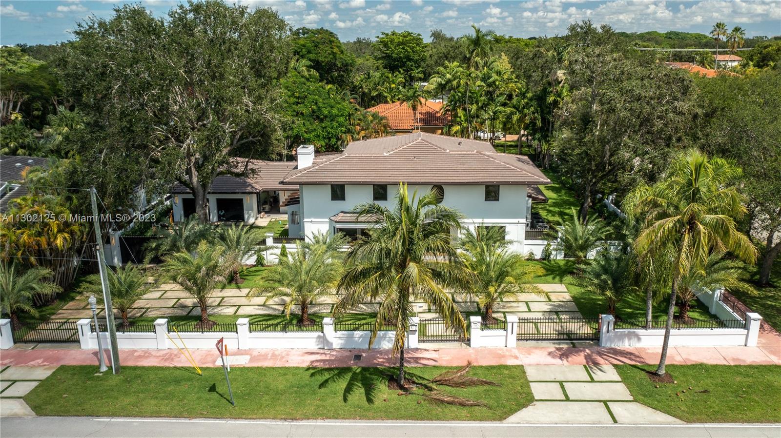 Ready for move in! This stunning home is located in the prime location of Coral Gables on an oversized gated corner lot. Completely custom rebuilt with high end modern finishes.3 year builders warranty. Gourmet kitchen features custom modern cabinetry, accent lighting, oversized island, double sinks, quartzite countertops, Miele appliances and gas stove. Wood flooring throughout adds elegance to every room. Each bedroom has it's own bath and an additional half bath for living area. Master bedroom has a wet bar as well as the entertainment room and family room. Laundry room with double washer and dryer. Two car garage with ample driveway for parking. Outside, enjoy the gas heated pool, trellis with cooking area, roofed terrace and balcony. Smart home features. Owner financing available.
