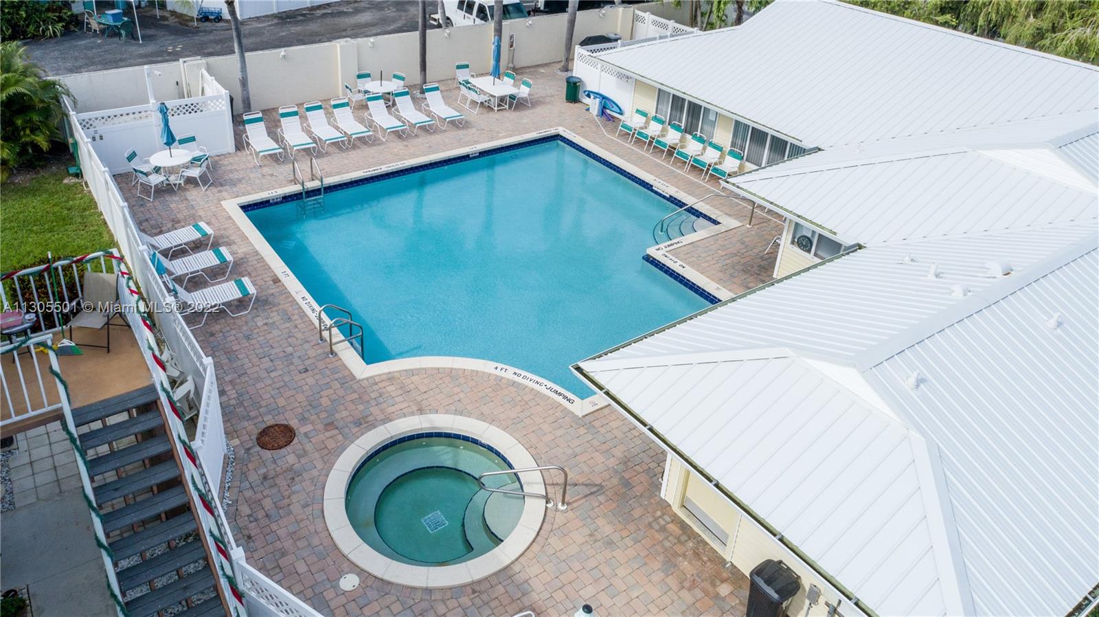 Aerial view of the pool taken from the front over the fence entrance to the pool area.
