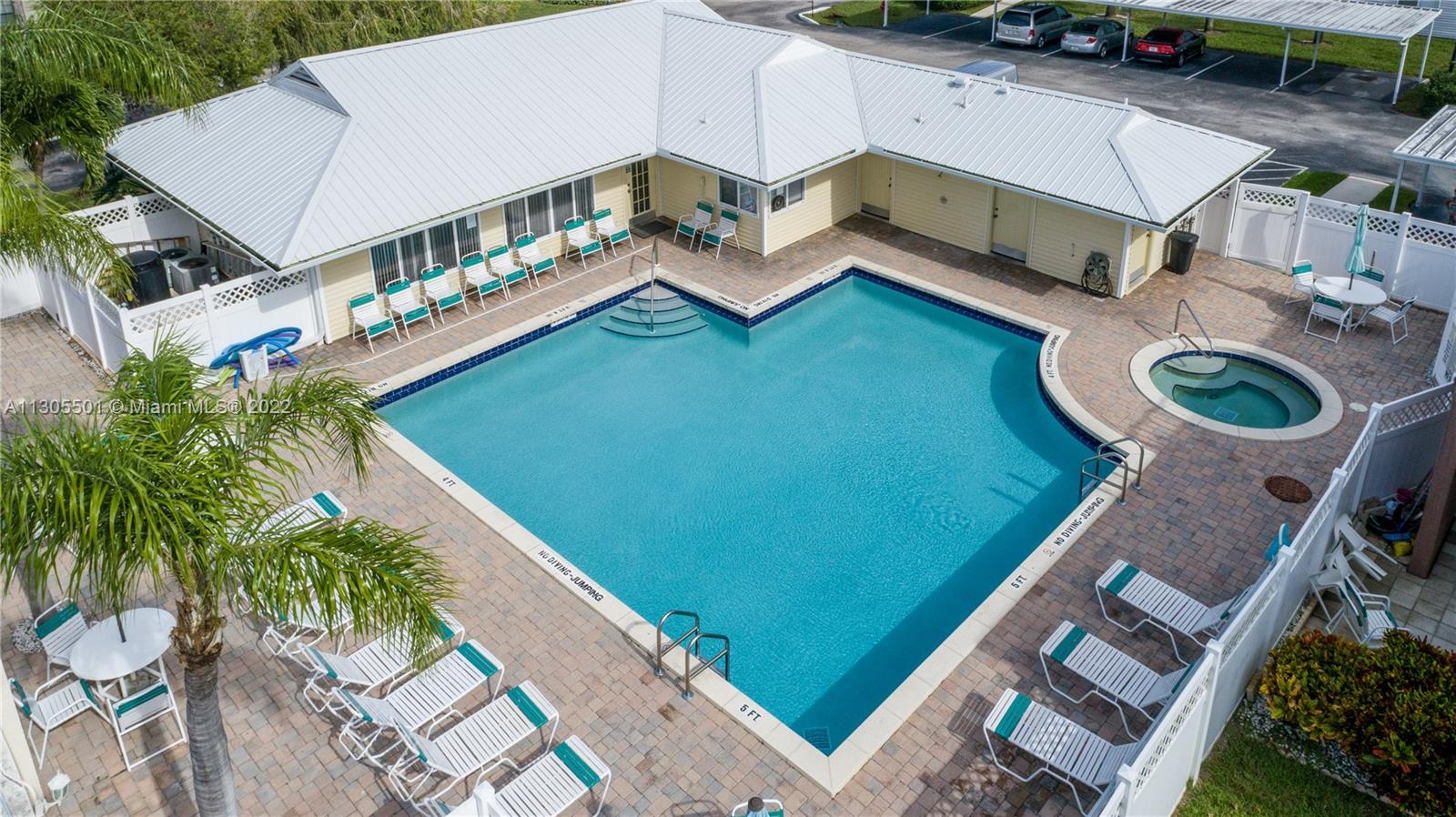 Aerial view of the pool taken from the back right showing the pool, sauna and clubhouse.