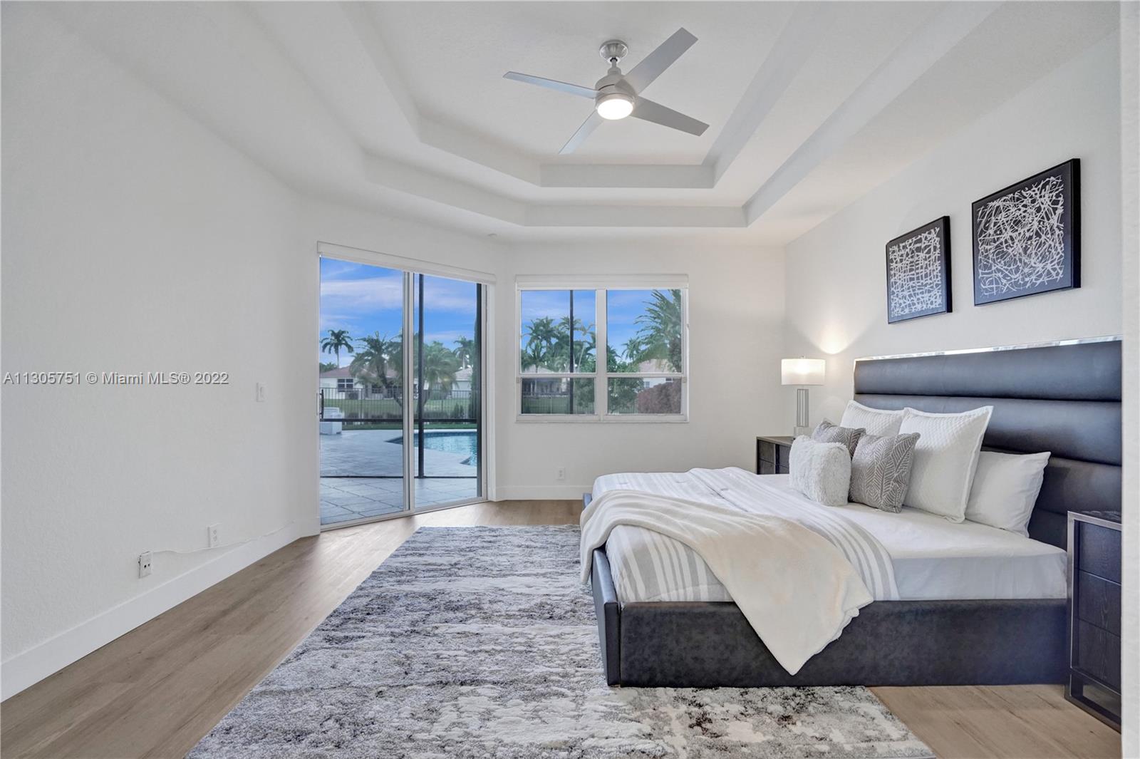 Freshly painted master suite with double coffered ceiling, modern ceiling fan, brand new luxury vinyl plank flooring, new high baseboards and amazing views!